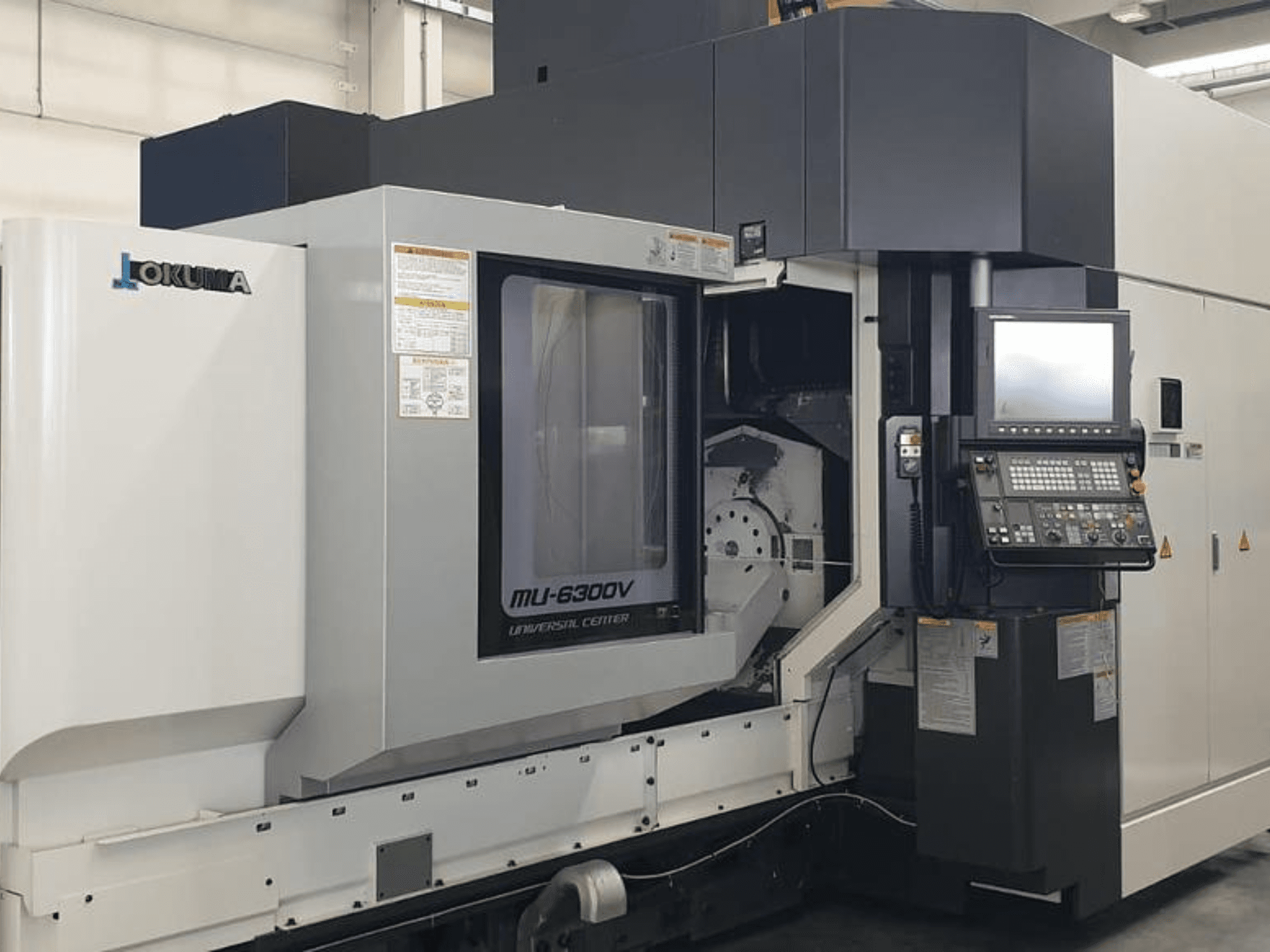 Vertikální obráběcí centrum Okuma MU 6300 V, čelní pohled na ovládací panel a detaily obráběcího prostoru.