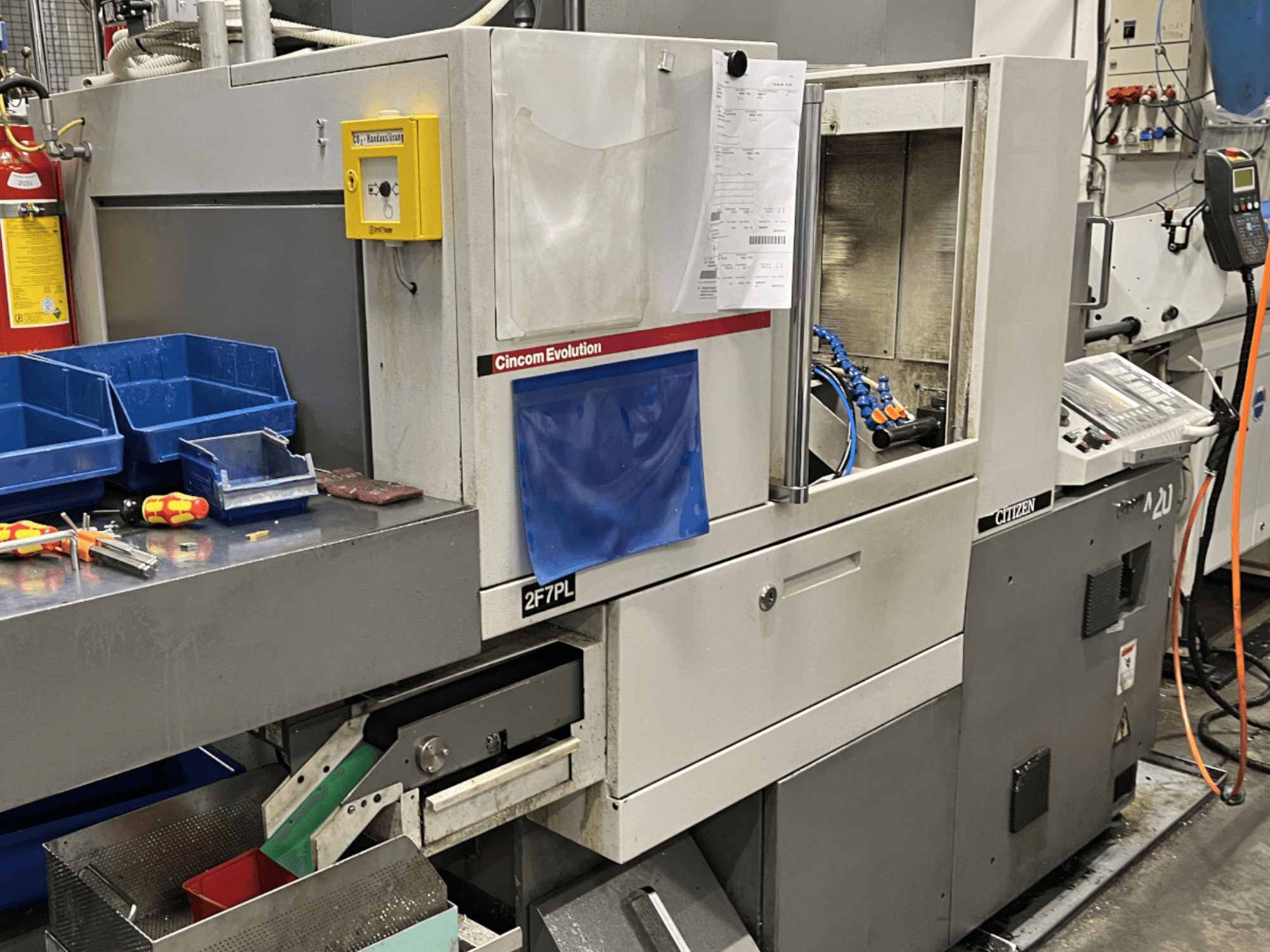 Obráběcí centrum Cincom Evolution 2F7PL, pohled zepředu; obsahuje ovládací prvky, zásobníky nástrojů a detailní ovládací panel.