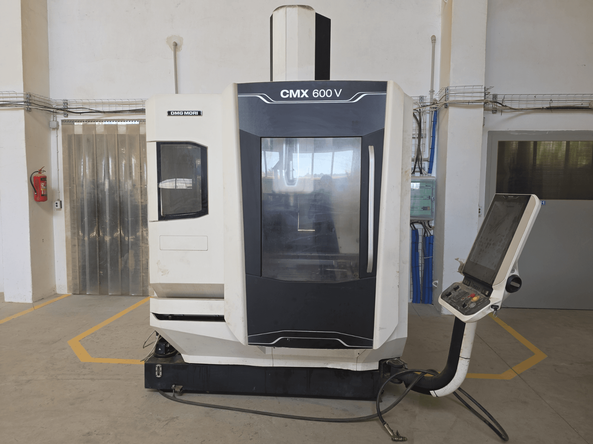 Vertikální obráběcí centrum DMG MORI CMX 600 V, pohled zepředu, ovládací panel a velké průhledové okno.