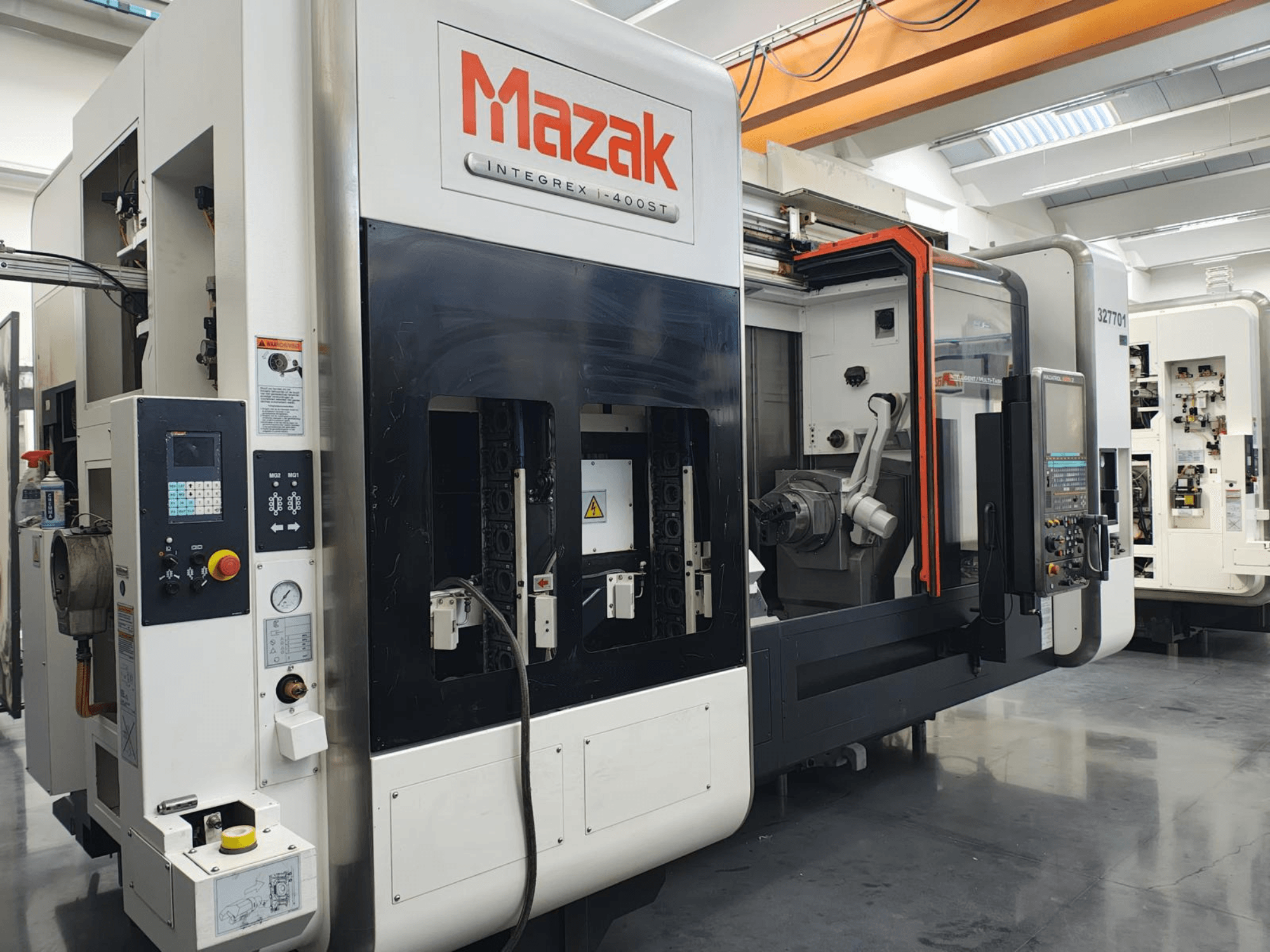 Mazak Integrex 400ST, pohled zepředu; CNC stroj s ovládacím panelem, vřeteny a robotickým ramenem viditelným v dílenském prostředí.