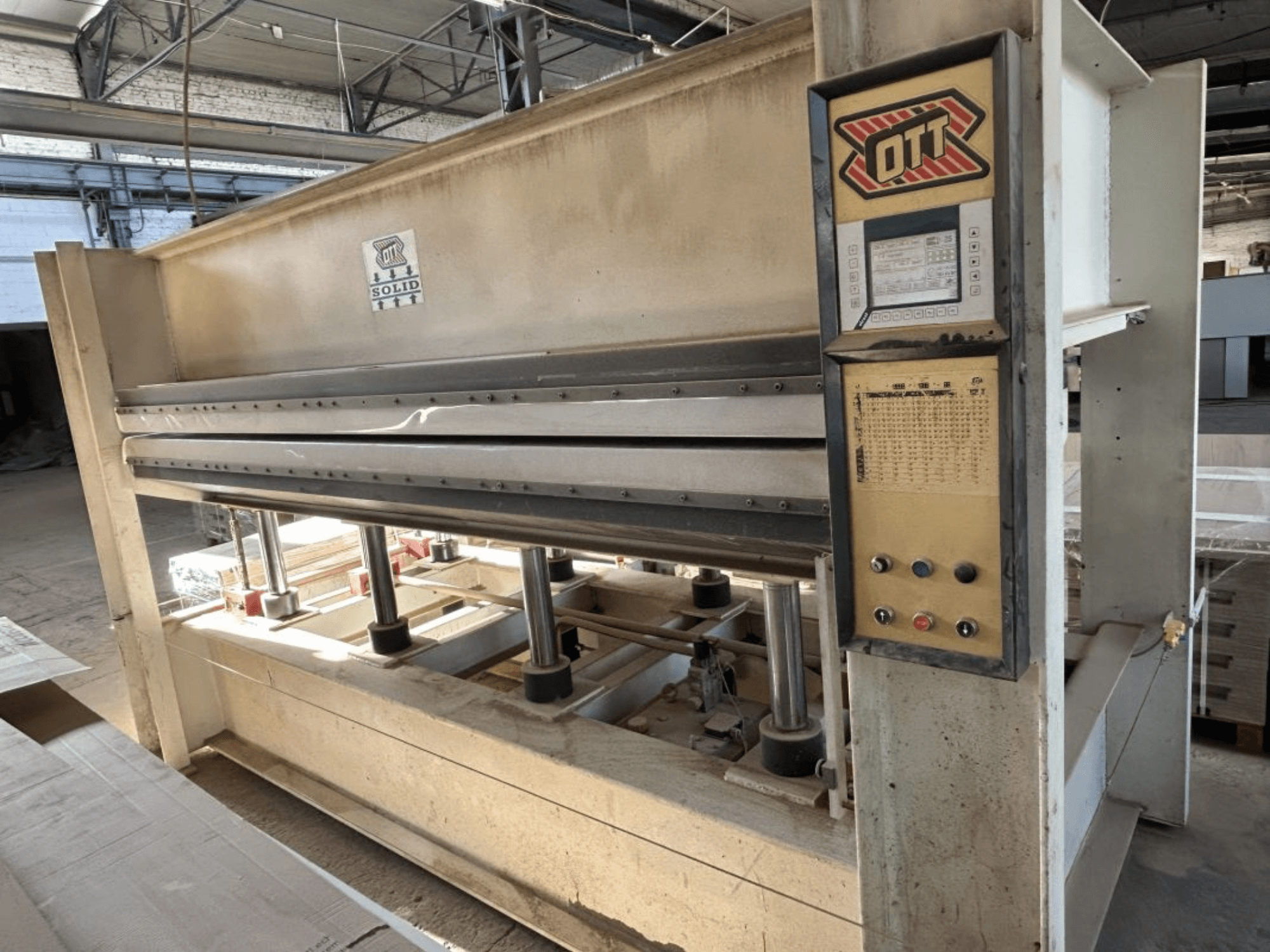 Pohled zepředu na laminovací lis OTT SOLID 16-32 s ovládacím panelem a hydraulickými komponenty.