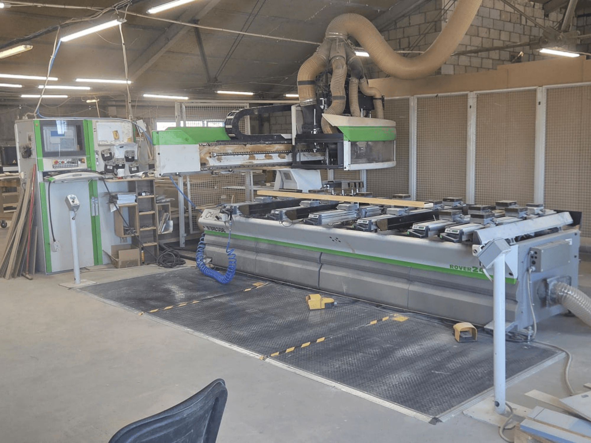 CNC obráběcí centrum BIESSE Rover 24S v dílně s ovládacím panelem a velkou pracovní plochou s dřevěnými díly.