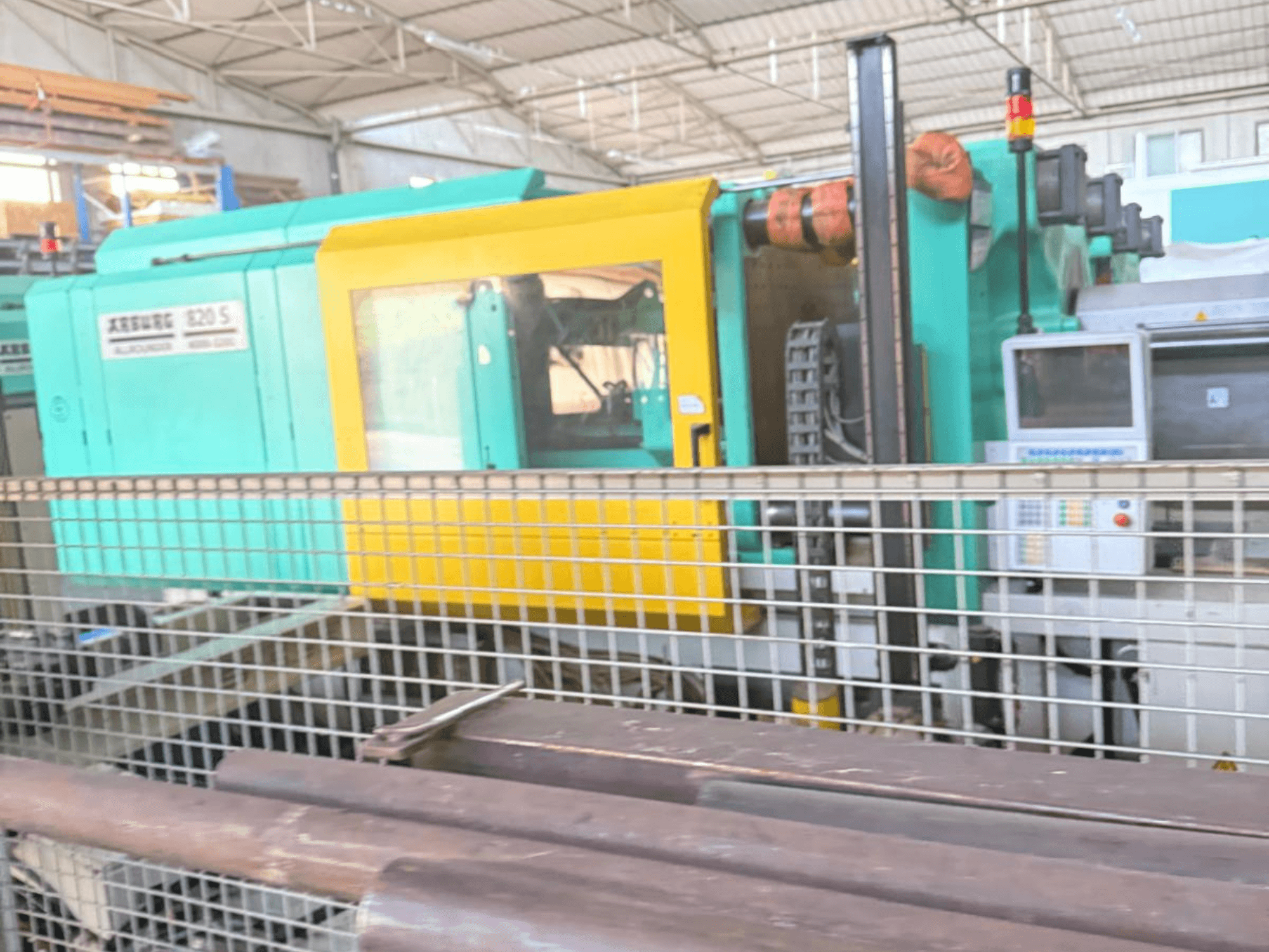 Hydraulický vstřikovací stroj Arburg SELECTA 820 S 4000-3200, boční pohled na ovládací panel a zářivě žlutý a teal design.