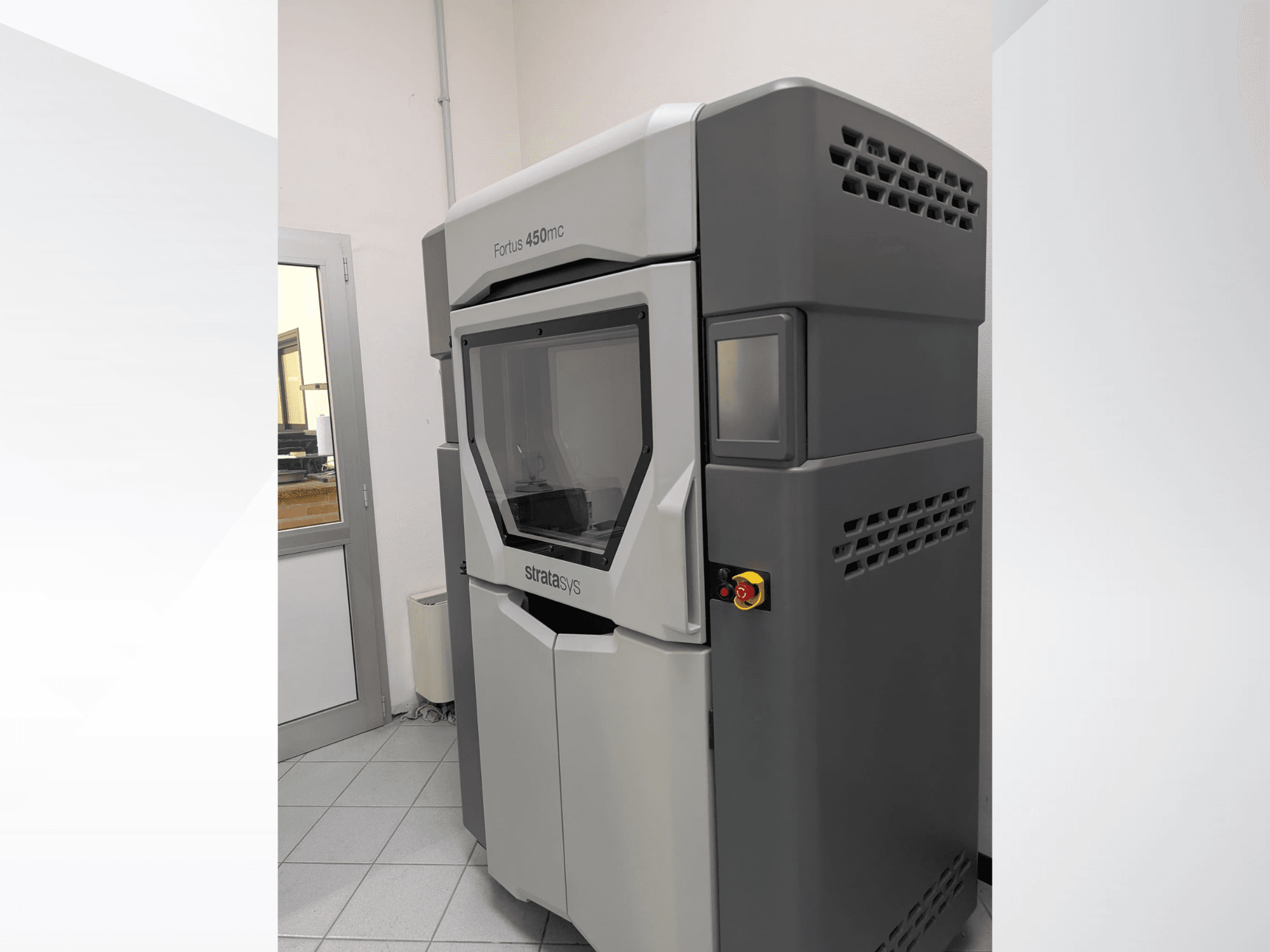 Plastová 3D tiskárna Stratasys FORTUS 450mc z bočního pohledu, na které je vidět elegantní design a ovládací panel.