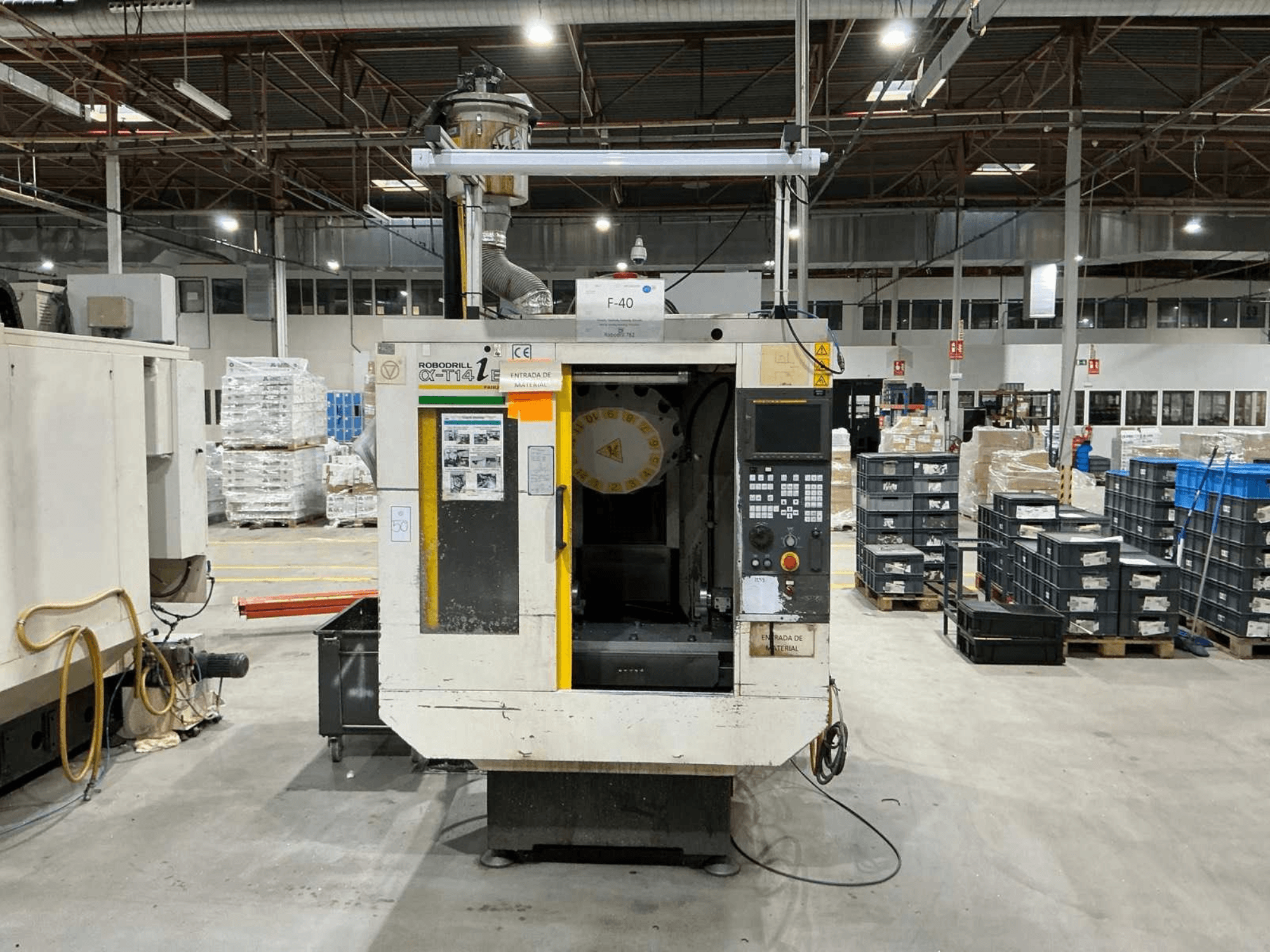 Vertikální obráběcí centrum FANUC ROBODRILL α-T14iB v továrně, pohled zepředu ukazuje ovládací panel a držák nástrojů.