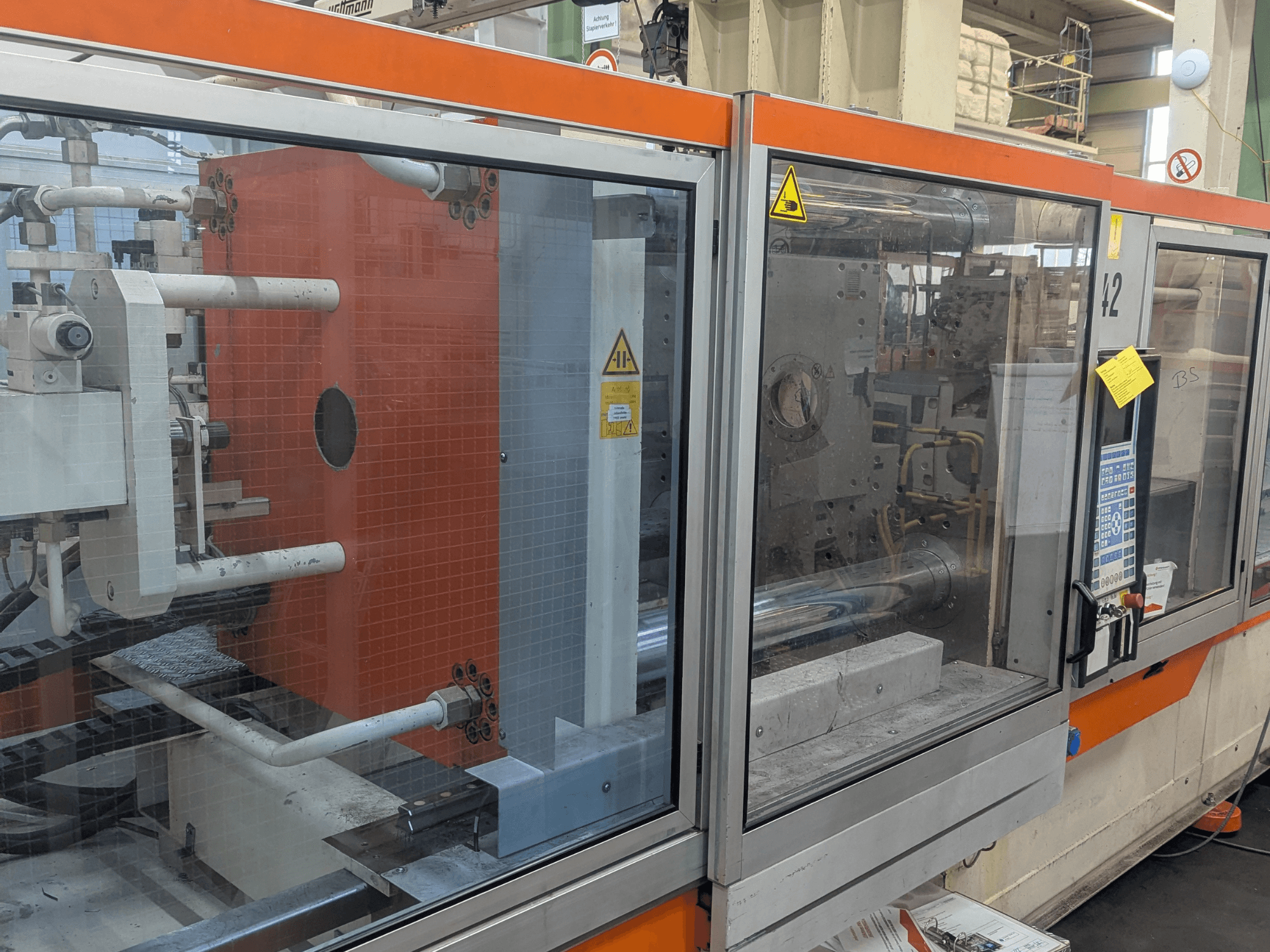 Pohled zepředu na hydraulický vstřikovací stroj DEMAG SYSTEC 80/420-310 s viditelným ovládacím panelem a komponenty stroje.