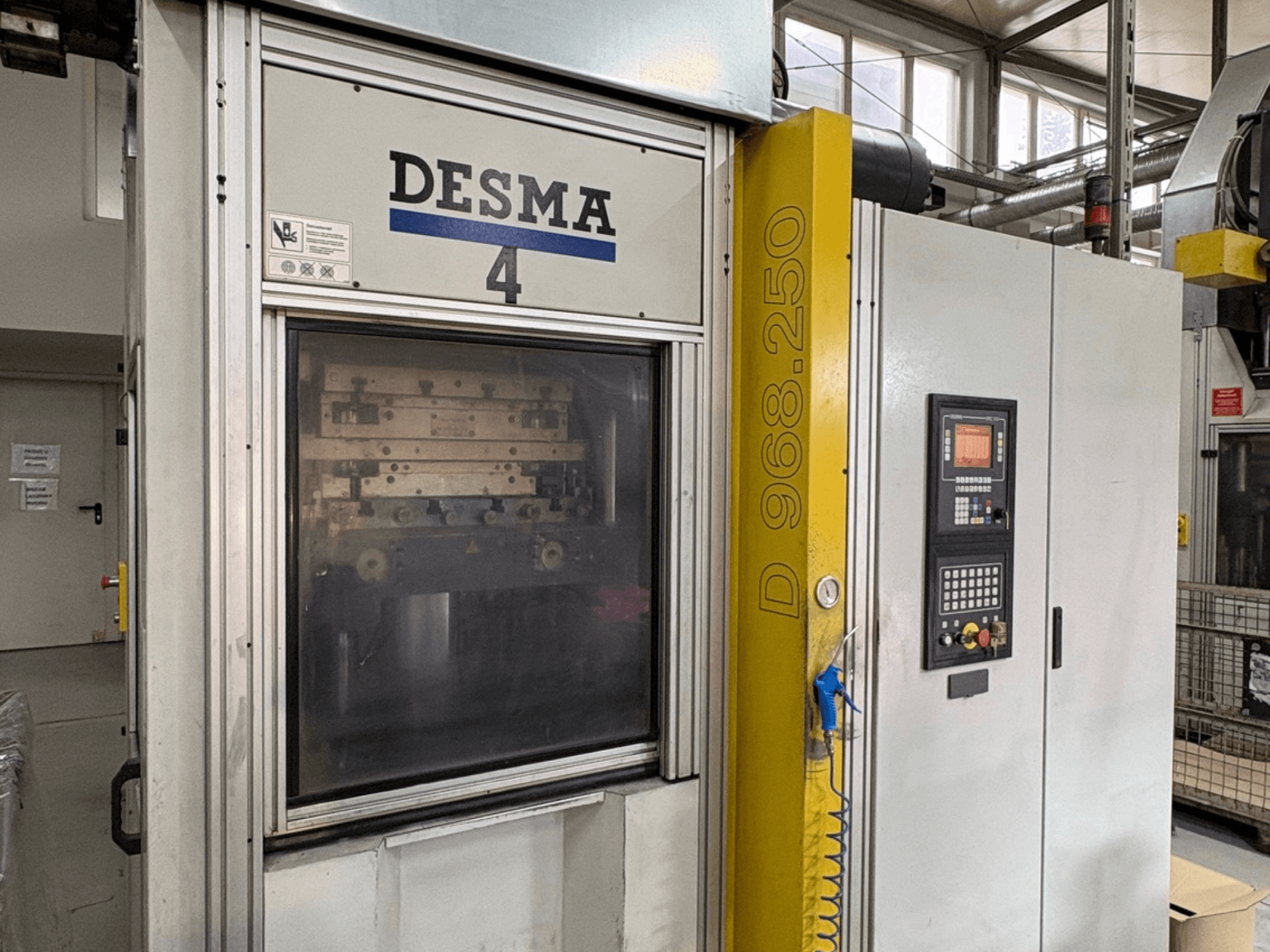 Vertikální vstřikovací stroj Kloeckner Desma 968.250, čelní pohled na ovládací panel a detaily stroje.