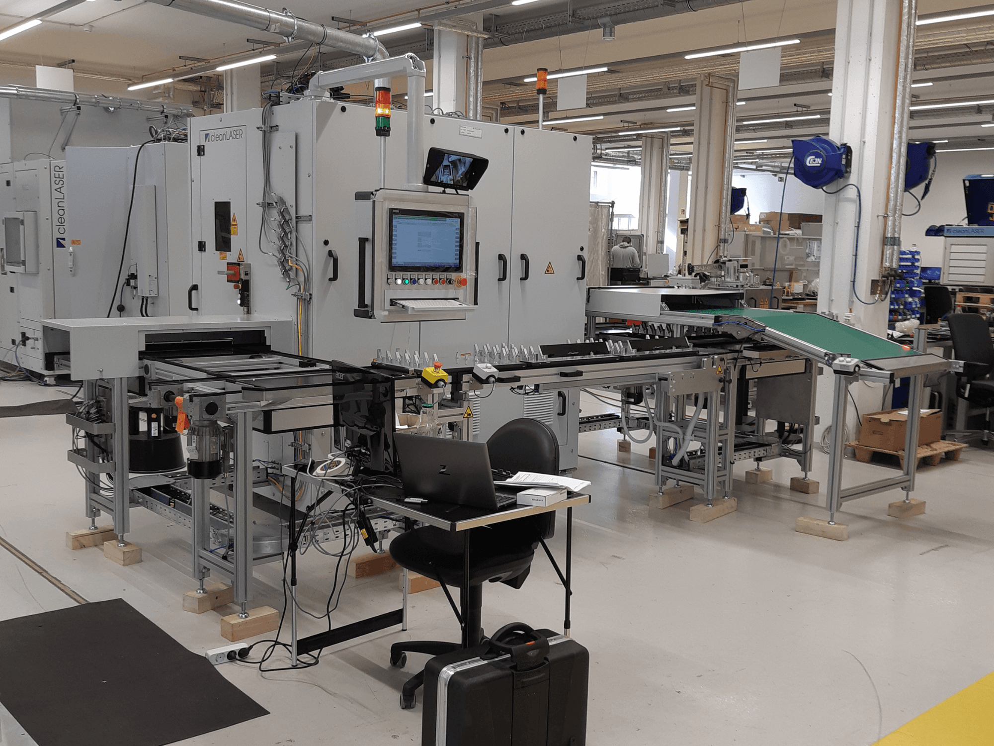 Obráběcí stroj CLEAN LASER clean CELL 3220 CL600, pohled zepředu, s viditelným ovládacím panelem, dopravníkem a pracovním prostorem v prostředí dílny.
