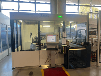 Průmyslová ohýbačka, model Piegatrice 3, pohled zepředu s ovládacím panelem a robotickým ramenem, v dobře osvětlené dílně.