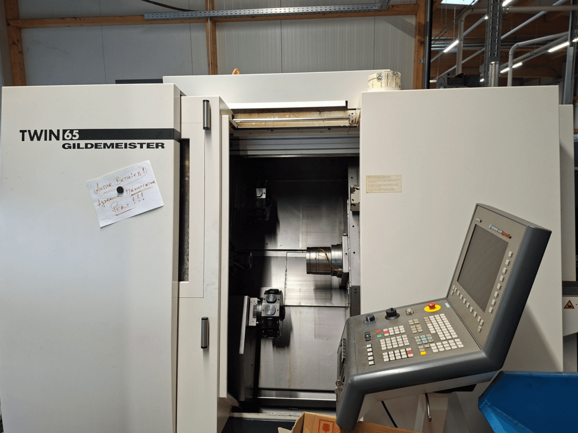 CNC soustruh Gildemeister TWIN 65, pohled zepředu na ovládací panel a částečně otevřenou komoru s viditelnými stroji.