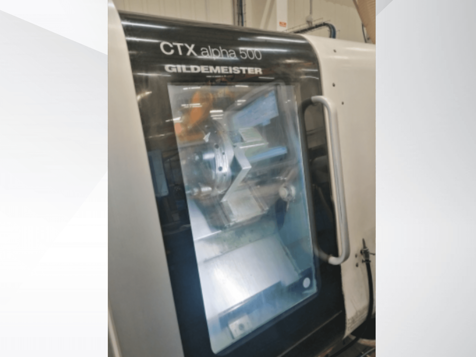 CNC stroj CTX alpha 500 Gildemeister, pohled zepředu, pohled na vřeteno a obráběcí prostor přes prosklené dveře.