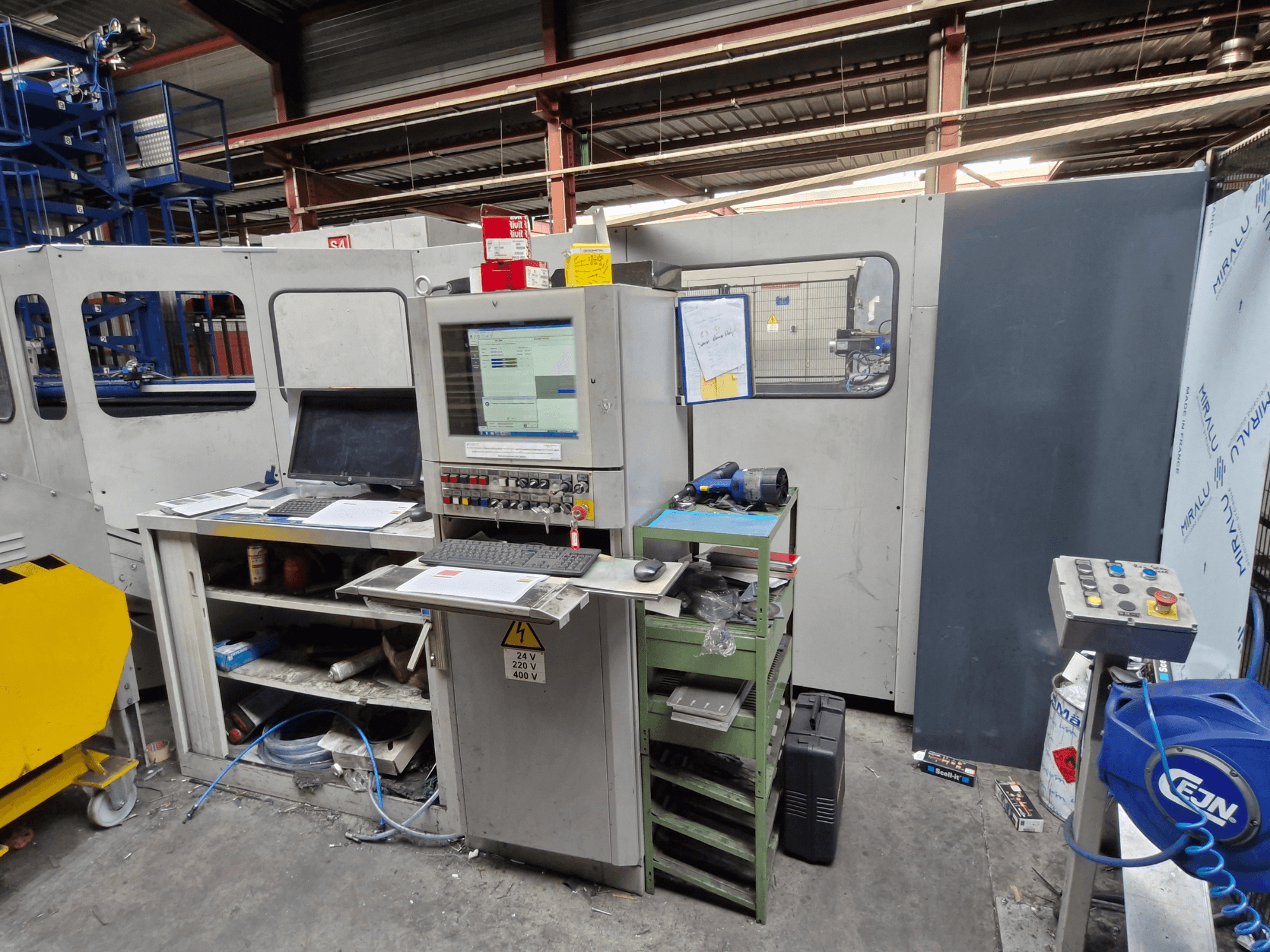 CNC děrovací stroj Salvagnini S4-40 v dílně, s ovládacím panelem s monitory a nástroji, pohled zepředu.