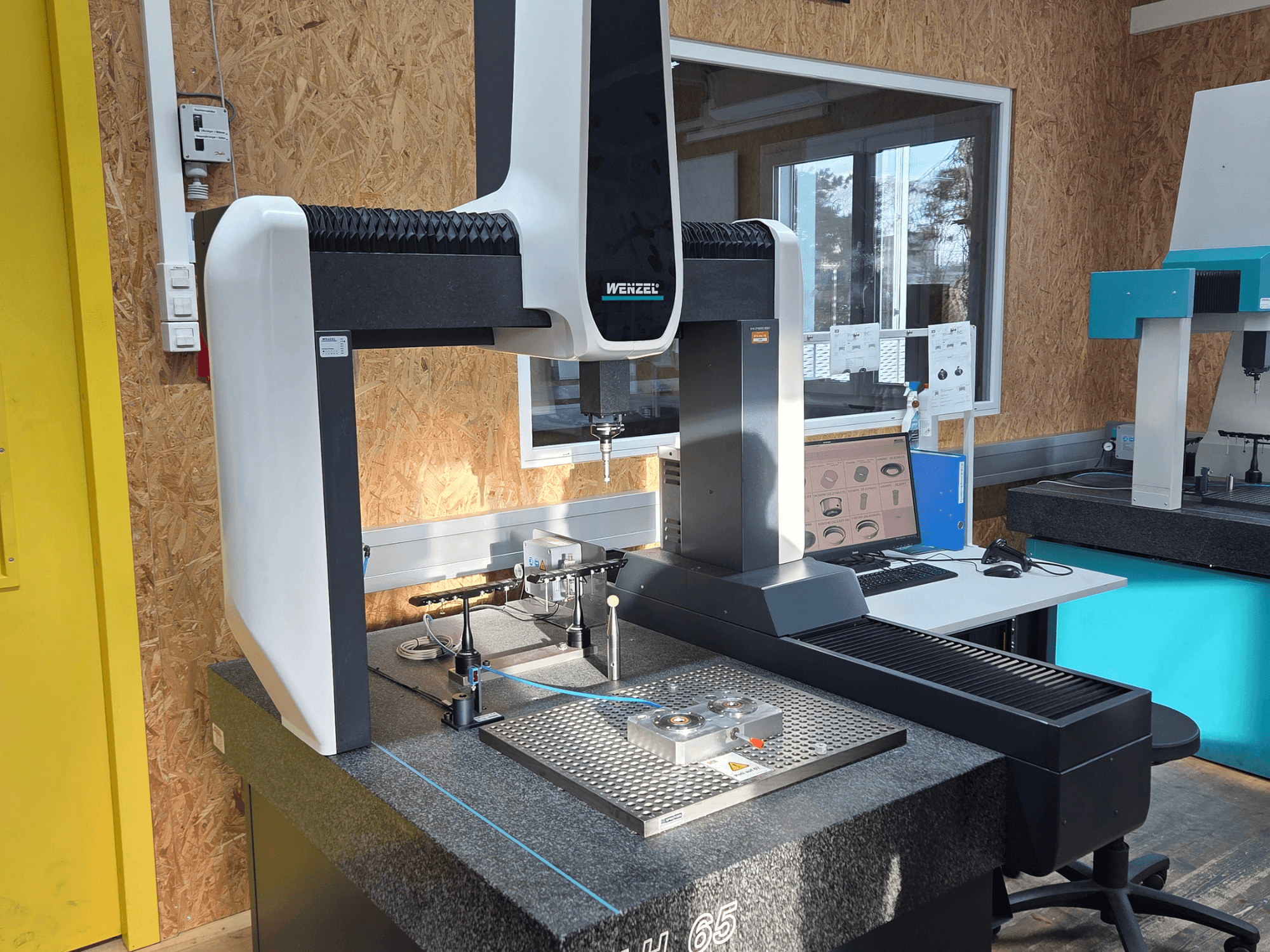 Souřadnicový měřicí stroj Wenzel LH 65 v laboratorním uspořádání, pohled zepředu, zobrazení měřicích nástrojů a monitoru.