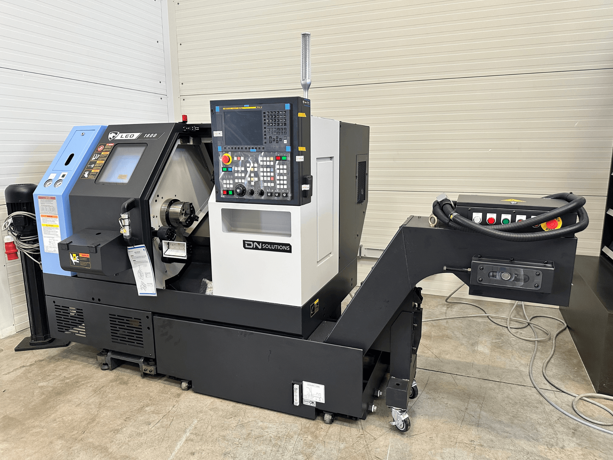 Pohled zepředu na soustružnické centrum DN SOLUTIONS Leo 1600 s digitálním ovládacím panelem a držákem nástrojů na černém podstavci.