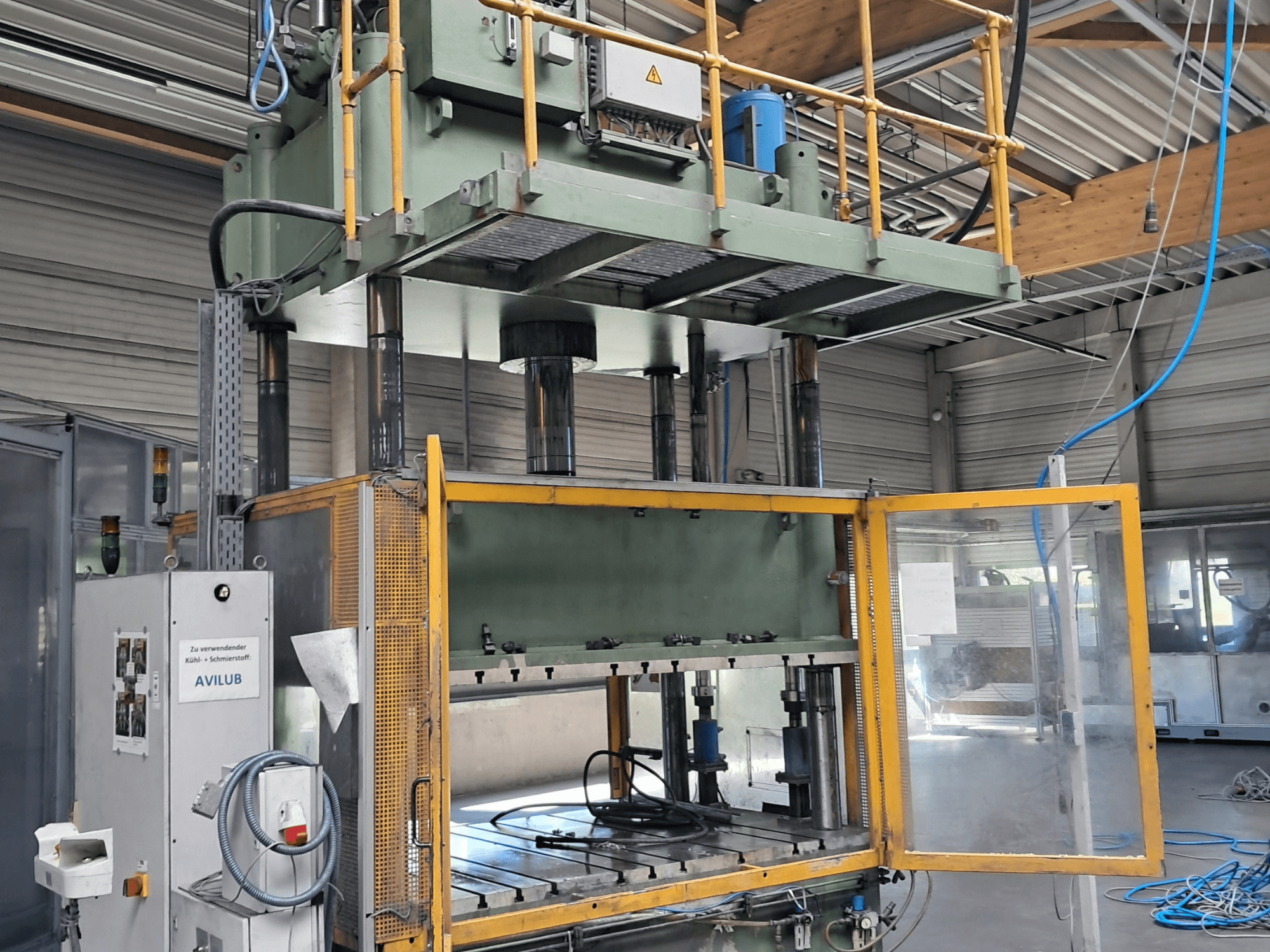 Kovový lis HS 4 160 od výrobce Other, pohled zepředu, s otevřenými dvířky, na kterém jsou vidět hydraulické válce a ovládací panel.