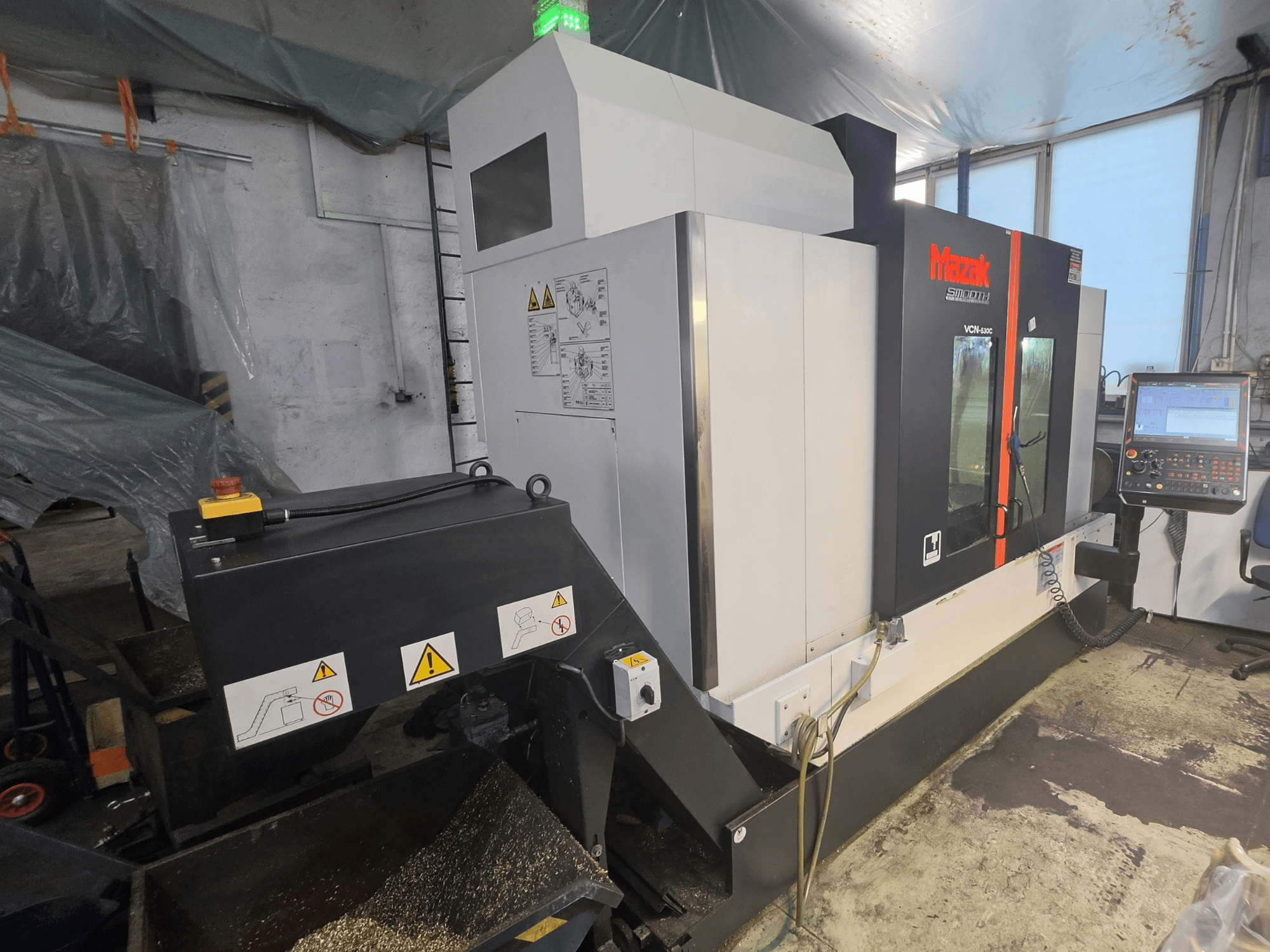 Vertikální obráběcí centrum Mazak VCN-530C – pohled zepředu, na kterém je vidět ovládací panel, řetěz na nástroje a provozní kontrolky.