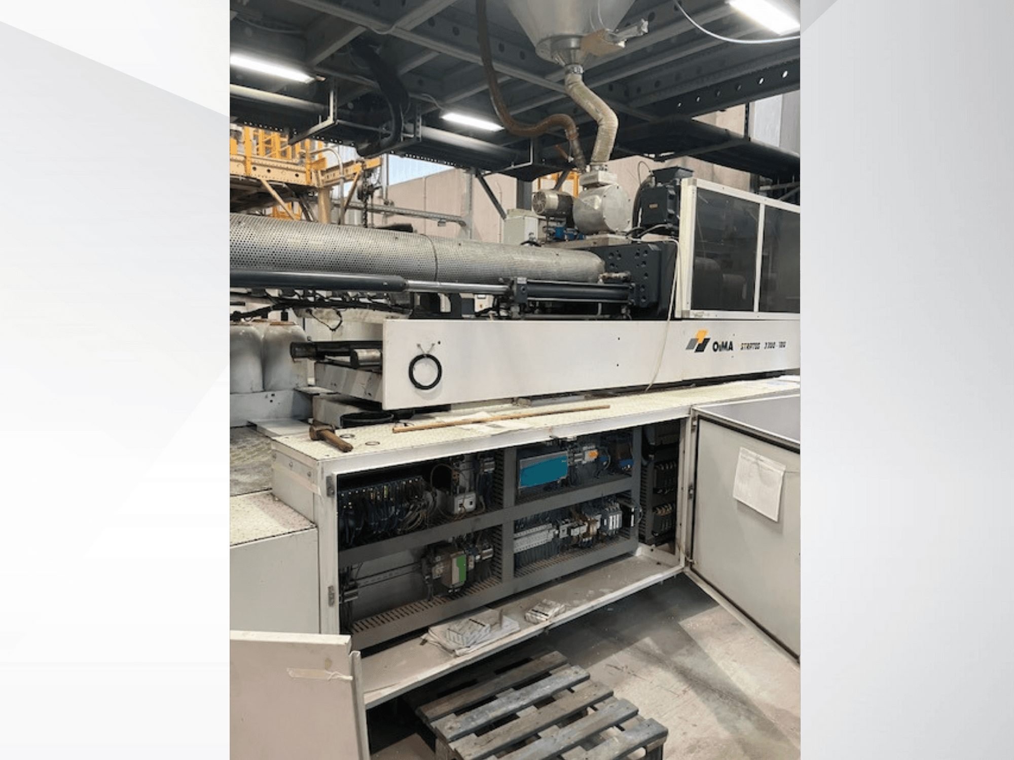 Přední pohled na extrudér OMA 3500 s ukázkou provozních částí, ovládacího panelu a detailů zapojení. Těžké stroje v průmyslovém prostředí.