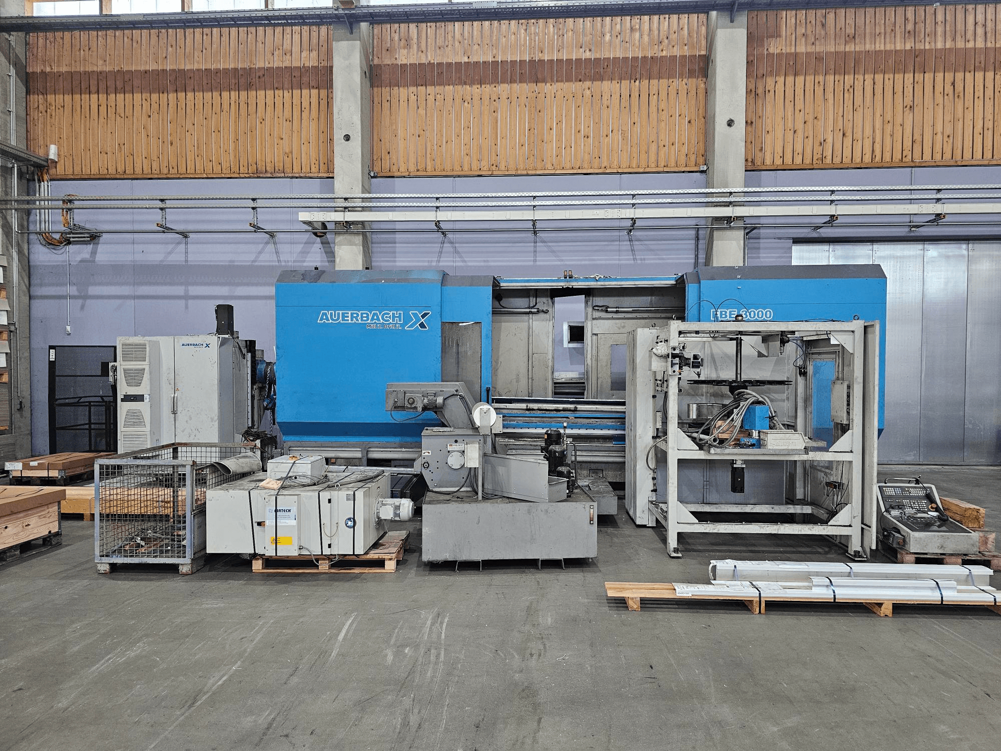 Stroj Auerbach X LBF-3000 v továrním nastavení, boční pohled, šedé a modré komponenty s viditelným ovládacím panelem.