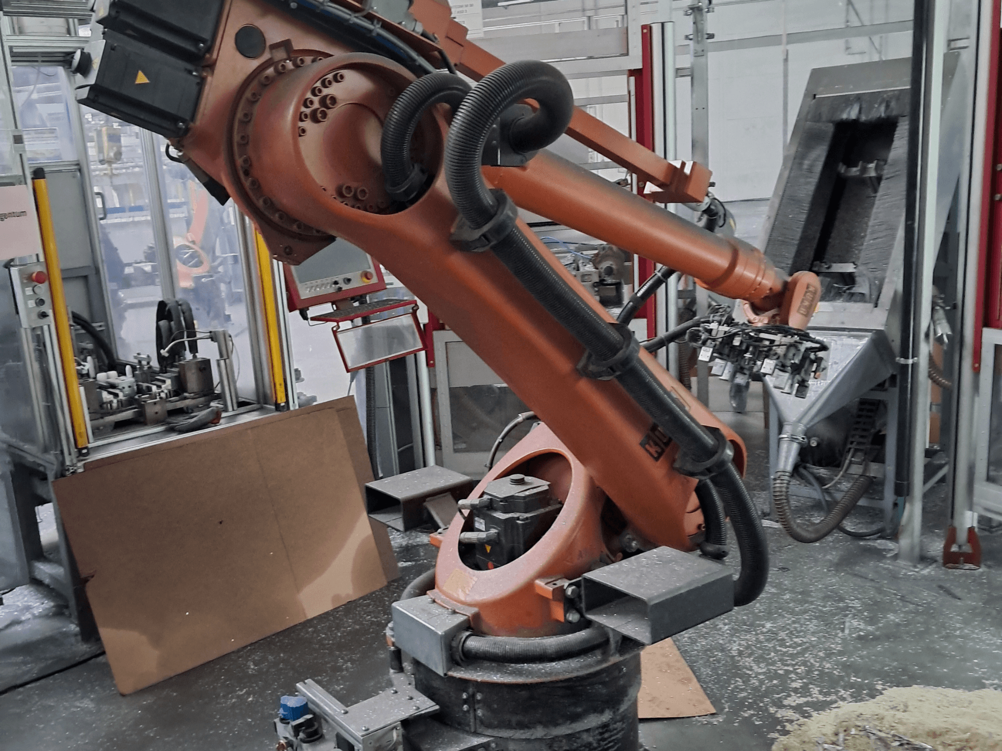 Robotické rameno KUKA KR 30 L 16-2 v dílně, pohled zepředu. Je vybaveno kloubovými spoji a v pozadí je vidět průmyslové pracoviště.