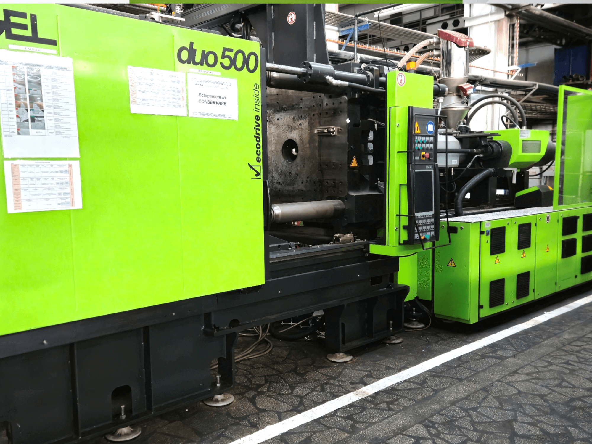 Zelený průmyslový stroj Ergotron duo 500, pohled zepředu; ovládací panel, technické údaje a bezpečnostní štítky zařízení.
