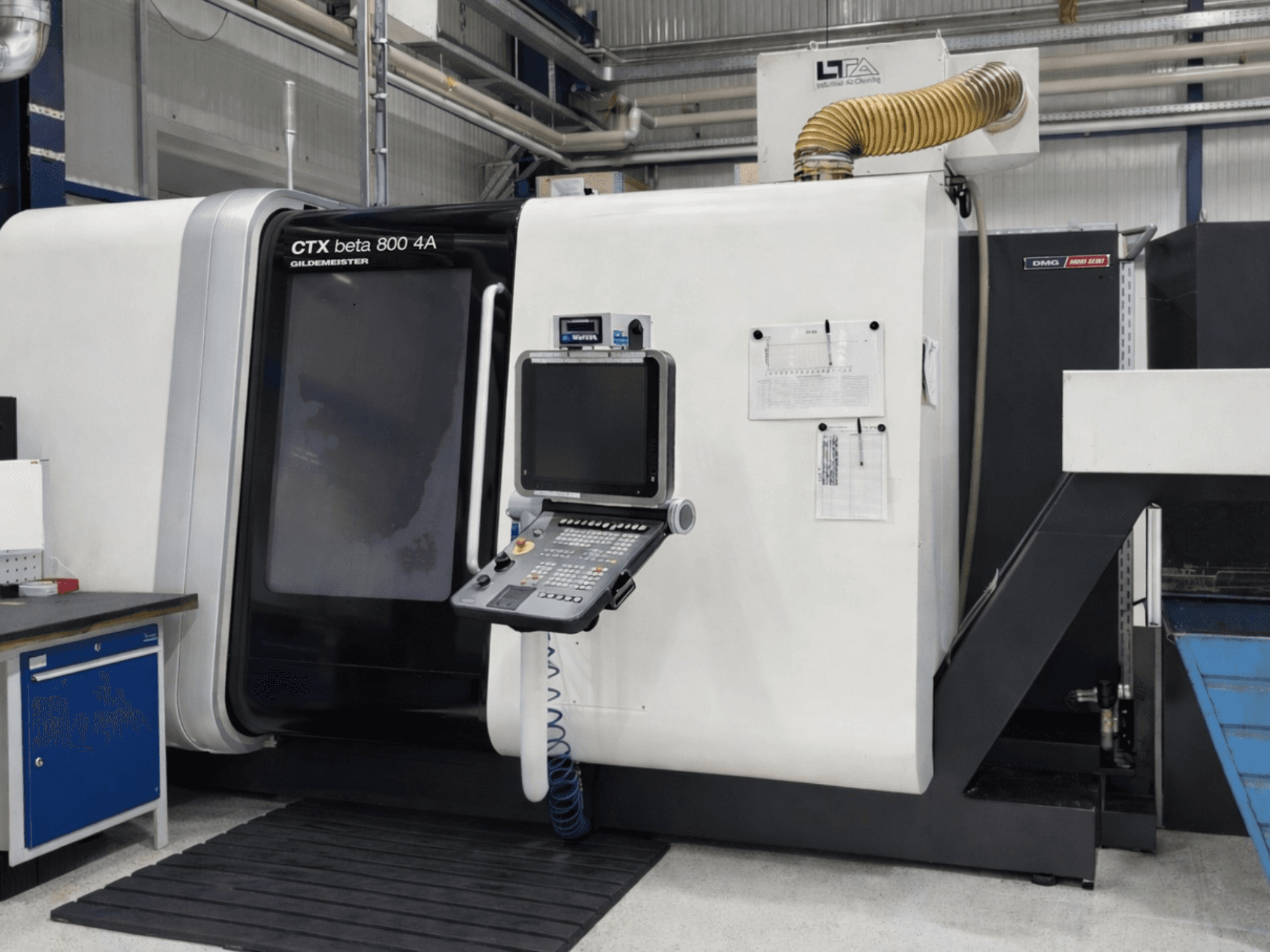 Vícevřetenový soustruh DMG CTX beta 800 4A, pohled zepředu, na kterém je vidět ovládací panel a provozní dokumentace.