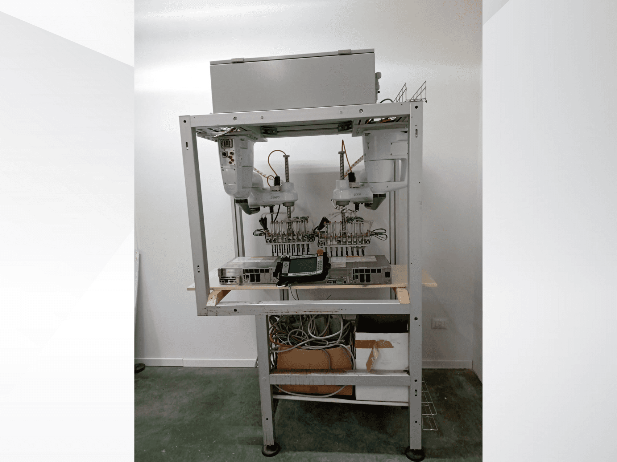 Automatizované robotické pracoviště se dvěma rameny, zobrazovací jednotkou a elektronikou na kovovém rámu, pohled zepředu, pokročilé technologické nastavení.