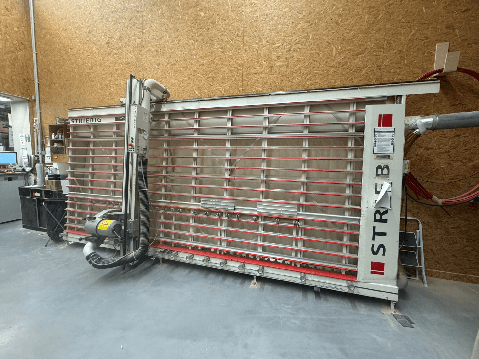 Obrysová pila STRIEBIG s velkým vertikálním kotoučem, boční pohled ukazuje odsávání prachu a ovládací panel. Ideální pro zpracování dřeva.