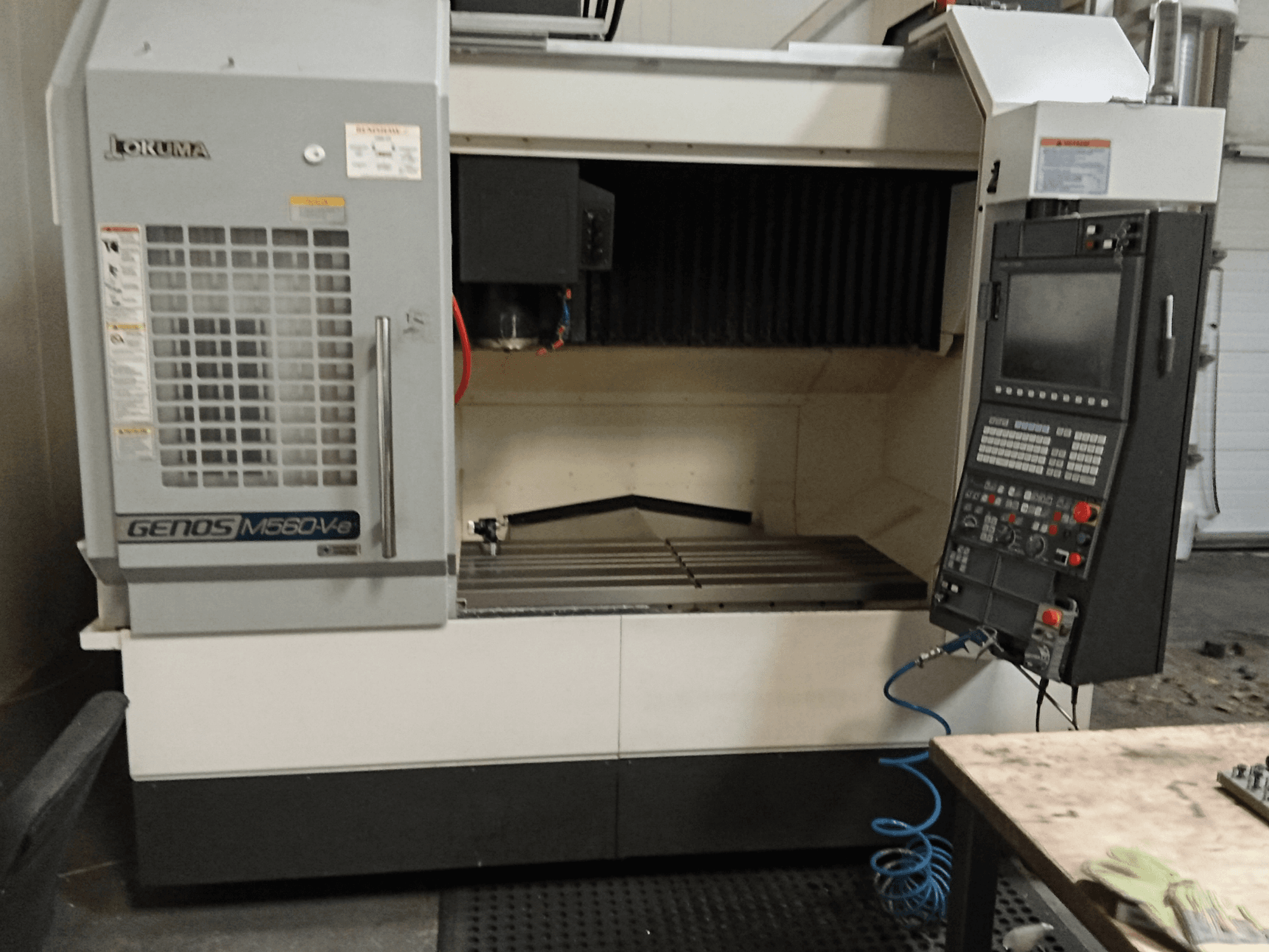 Okuma GENOS M560-V, čelní pohled na vertikální obráběcí centrum s ovládacím panelem, CNC rozhraním a viditelným řezným prostorem.