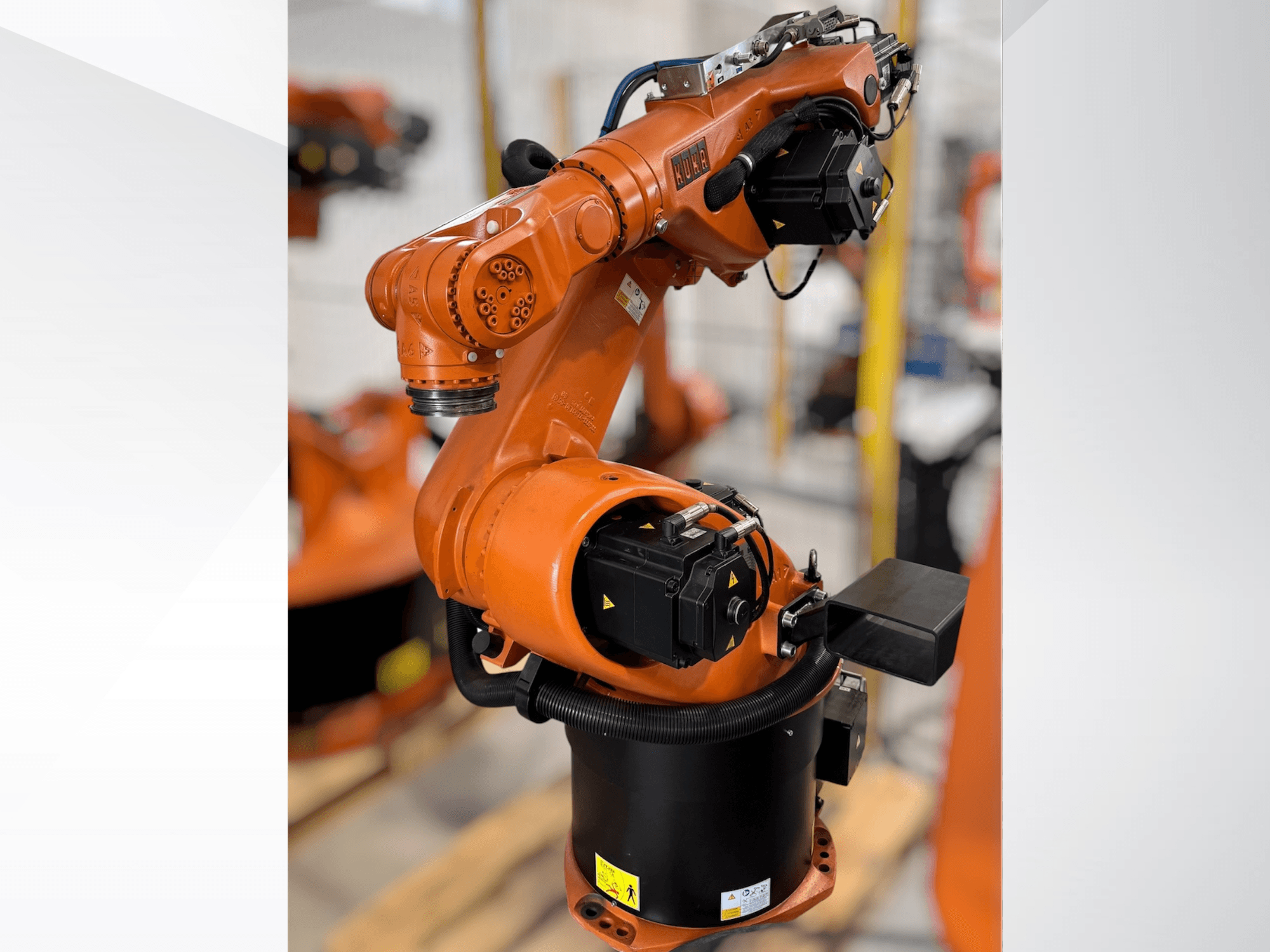 Robotické rameno KUKA KR 60-3 v oranžové barvě; boční pohled ukazuje základnu, klouby a řídicí moduly pro automatizační úlohy.