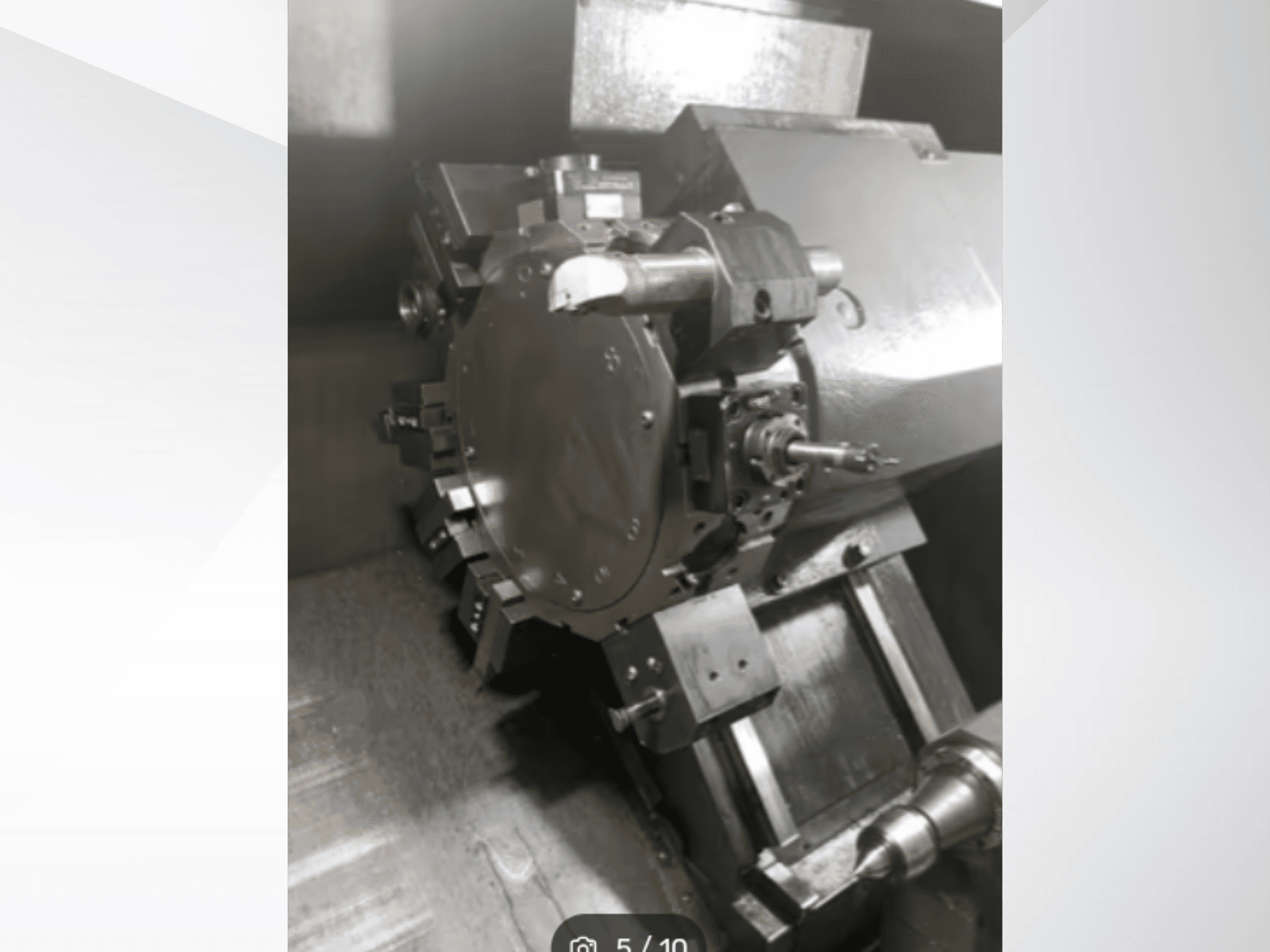 Detailní záběr přesného strojního dílu, na kterém jsou vidět ozubená kola a kovové součásti, při pohledu z úhlu. Značka není viditelná.