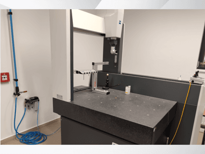 Měřicí zařízení MSR v laboratoři, pohled zepředu na žulový stůl, kalibrační kouli a připojené nástroje.