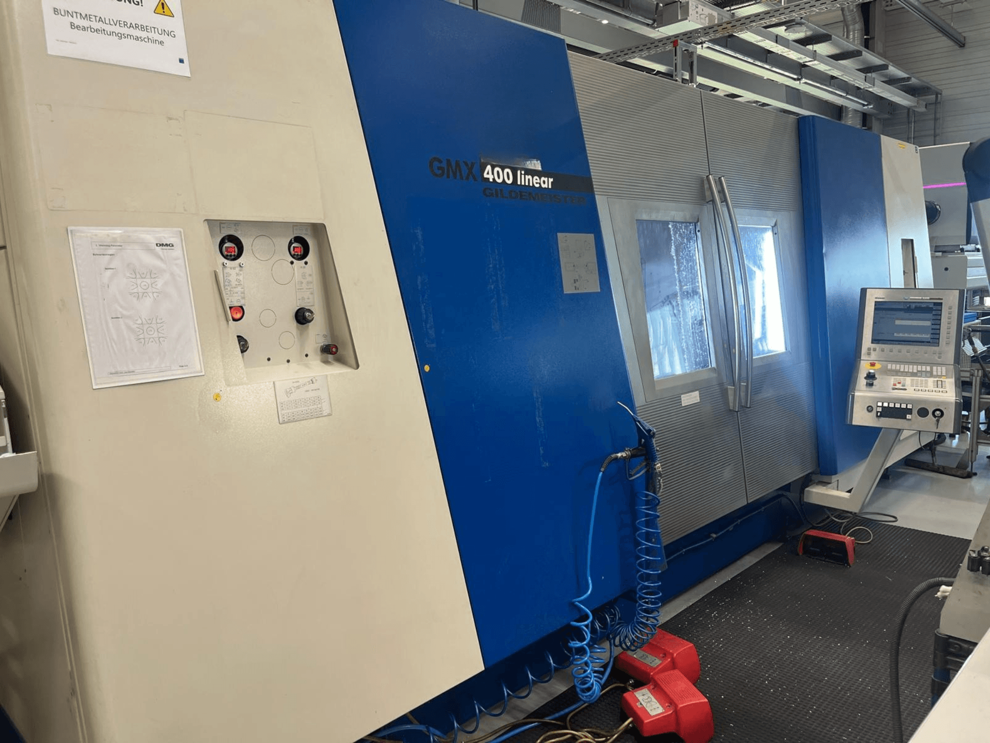 Lineární soustružno-frézovací centrum Gildemeister GMX 400, pohled zepředu znázorňující ovládací panel, systém chlazení a ovládací tlačítka.