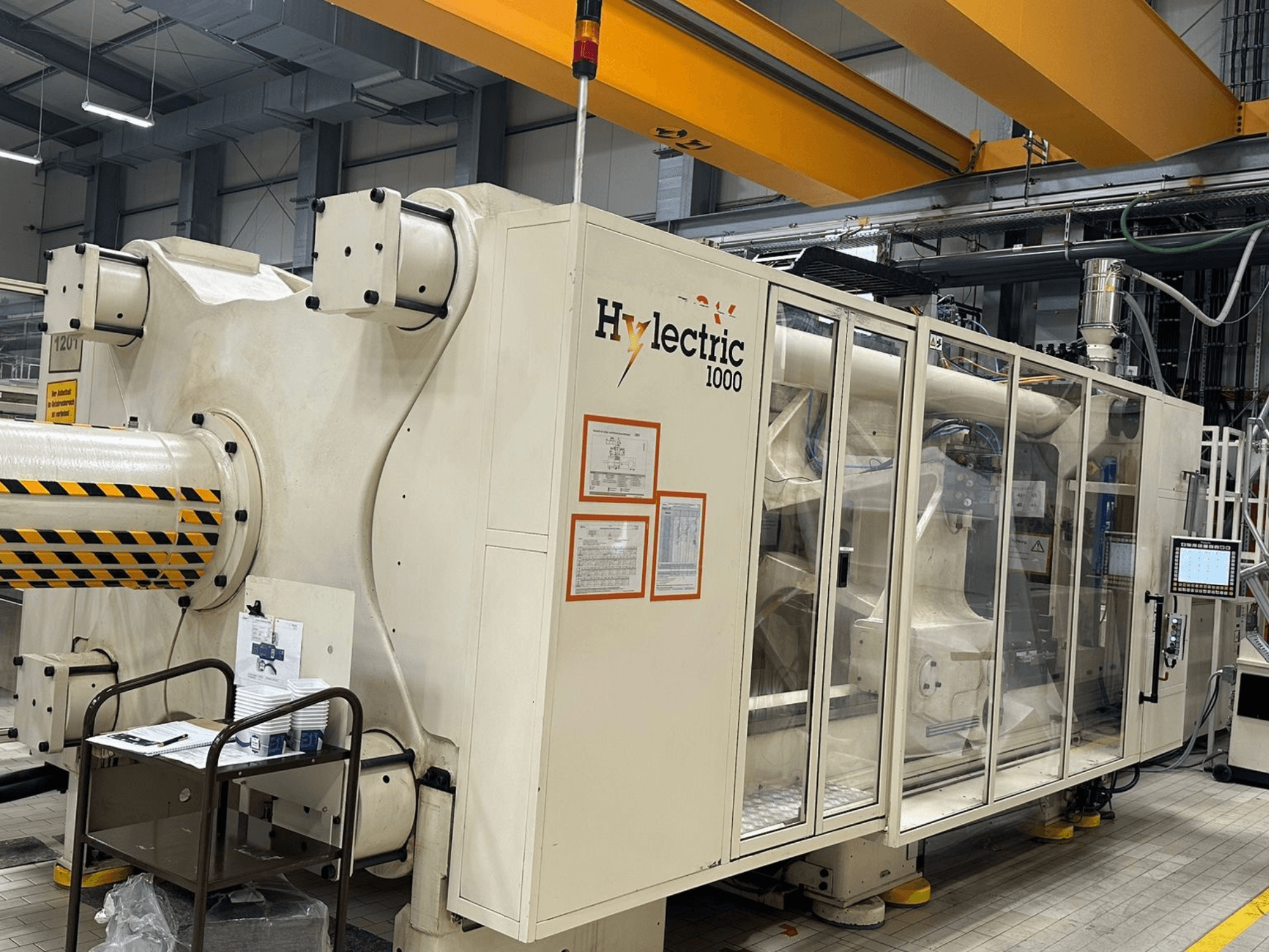 Elektrický vstřikovací lis Husky Hylelectric H1000 RS95/80, boční pohled s viditelným ovládacím panelem a bezpečnostními prvky.
