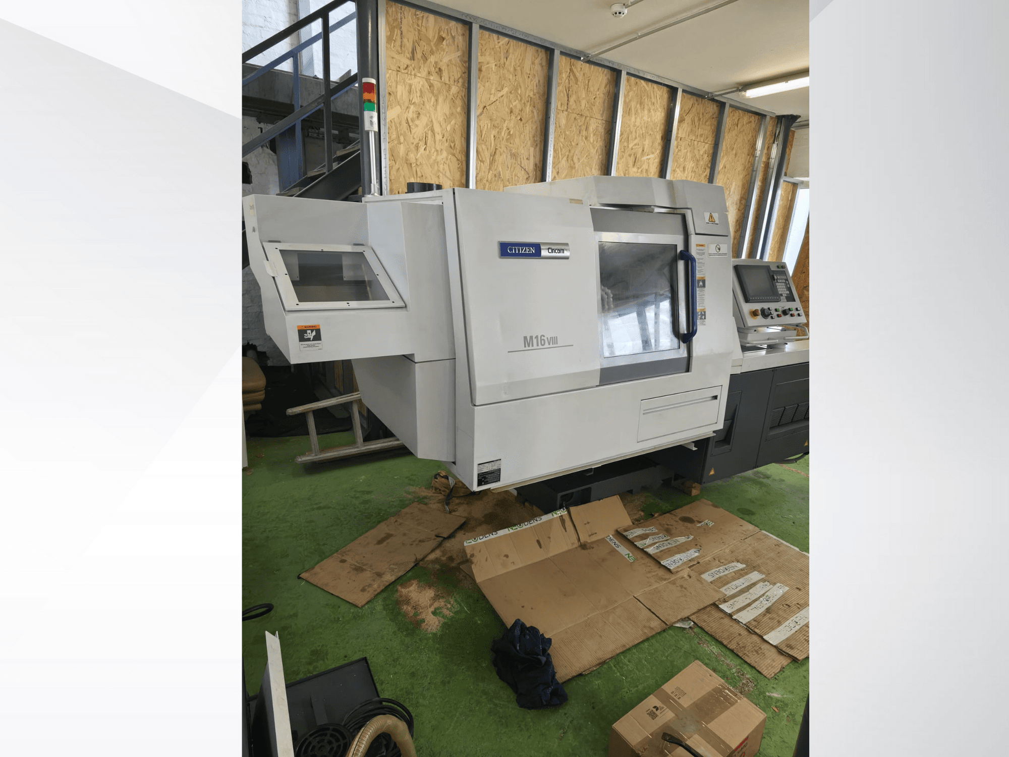 Soustruh Citizen M16VIII CNC v čelním pohledu, s ovládacím panelem a bezpečnostními výstražnými světly, umístěný na zelené podlaze.