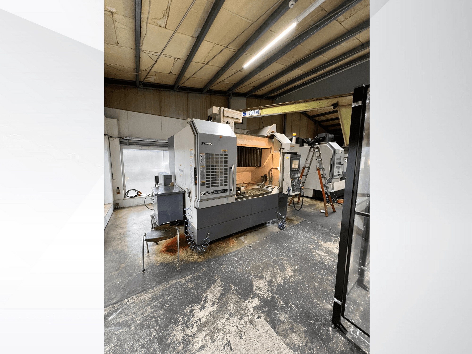 Stroj GRETOS 750 CNC v dílně, pohled zepředu, zobrazen ovládací panel a pracovní plocha s nástroji, v pozadí viditelný žebřík.