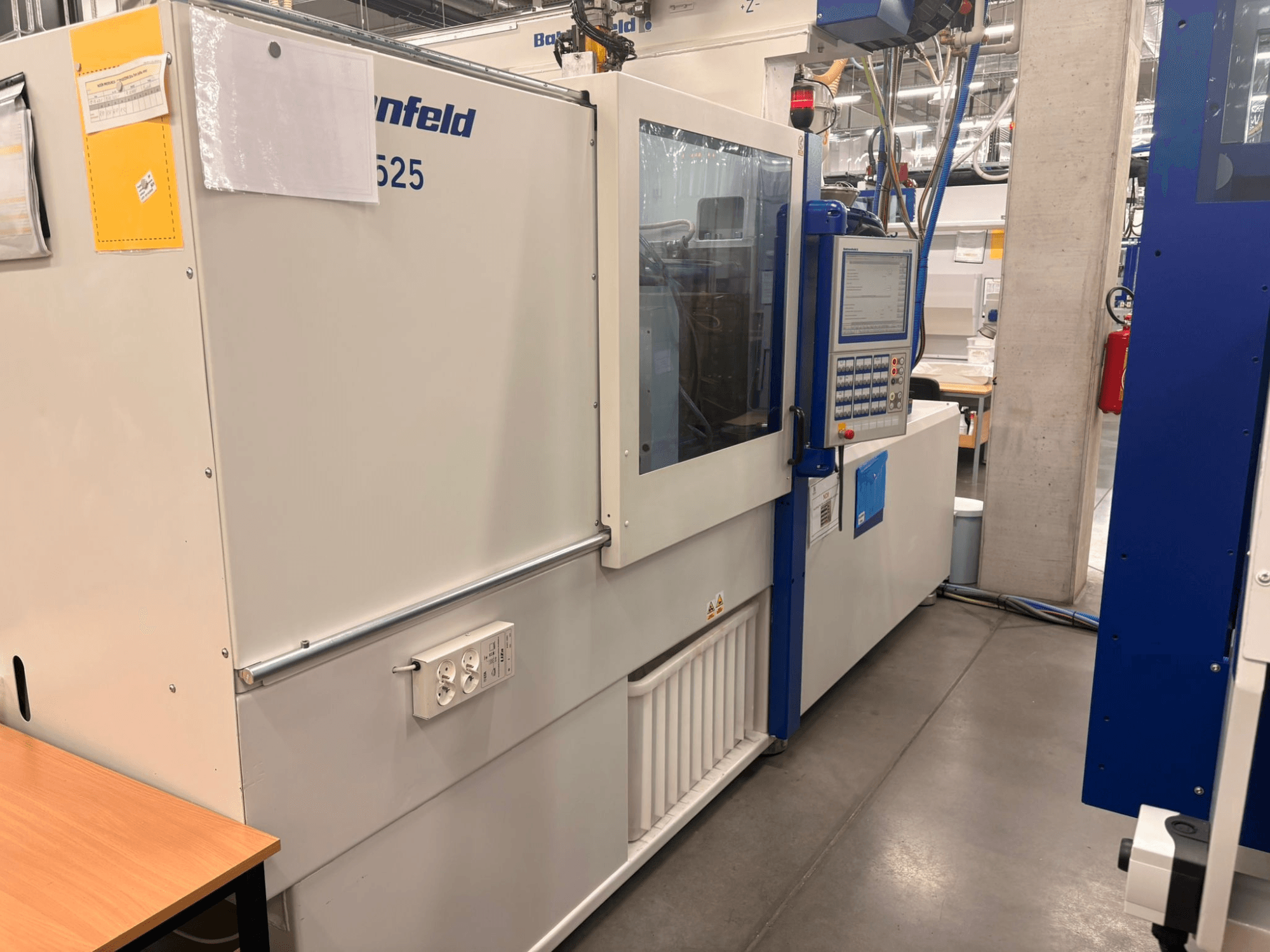 Stroje Arburg, model 620S, čelní pohled na ovládací panel a napájecí porty v továrním prostředí.