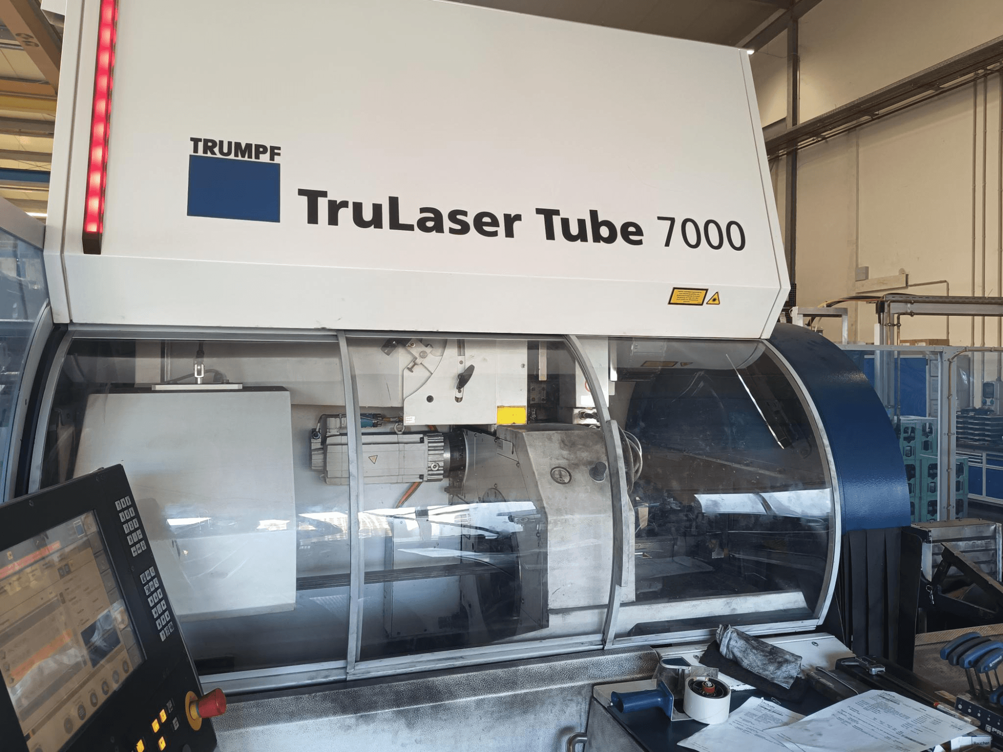 TRUMPF TruLaser Tube 7000, čelní pohled na stroj s ovládacím panelem, který ukazuje funkce laserového řezání a pracovní prostor.