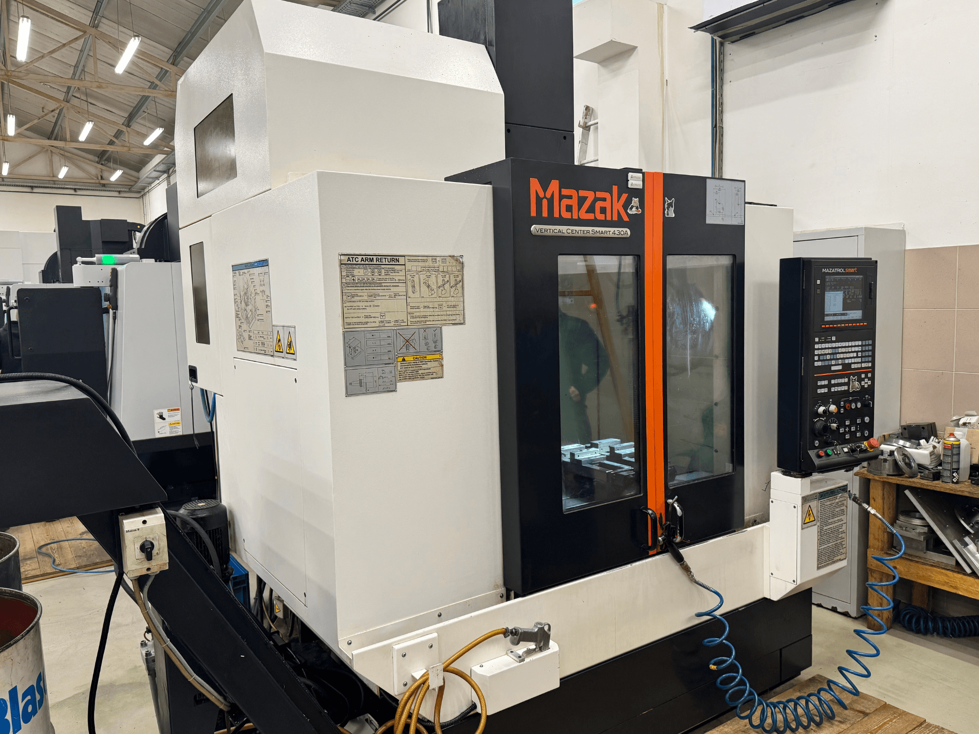 Vertikální centrum Mazak Smart 430A, pohled zepředu; CNC frézka s viditelným ovládacím panelem, průhledným krytem a držákem nástrojů.