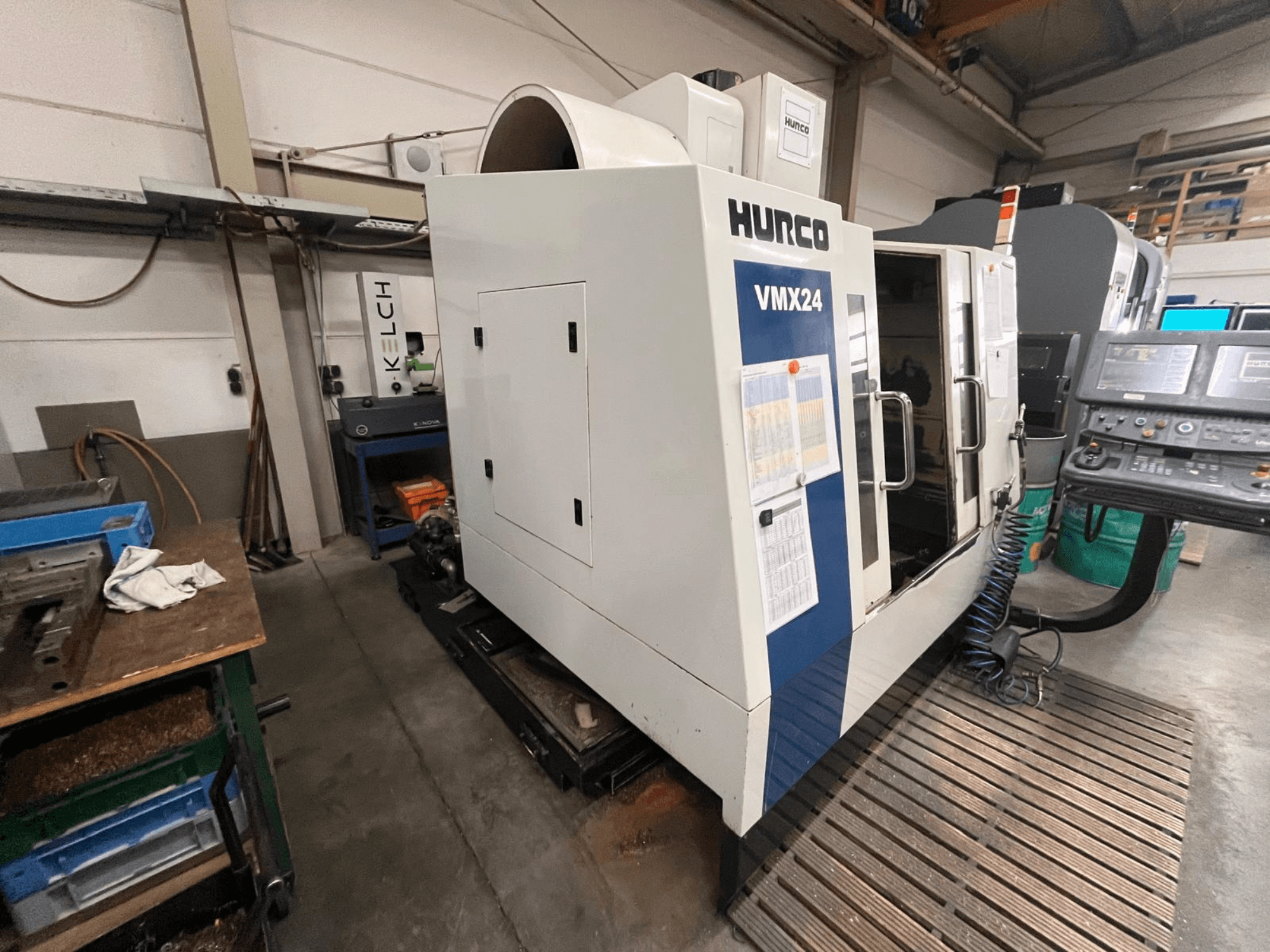CNC stroj Hurco VMX24 v dílně, pohled zepředu; ovládací panel a otevřené přístupové dveře.
