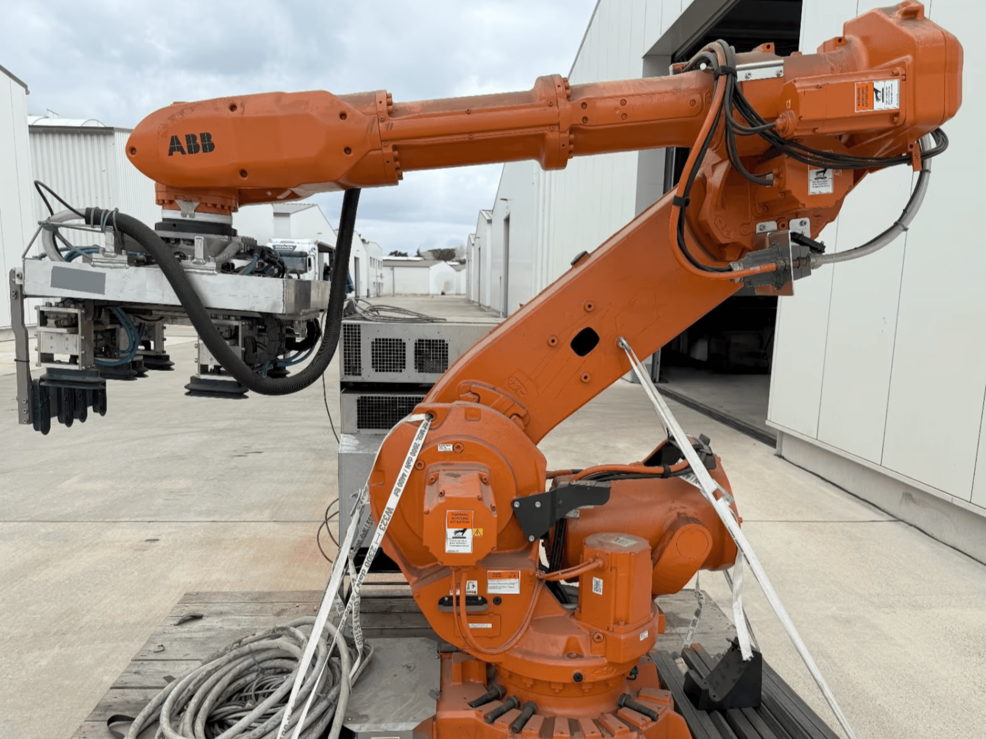 Robotické rameno ABB RB 6600-130/3.2 v bočním pohledu, s oranžovým robotickým ramenem s chapadlem a viditelnou kabeláží.