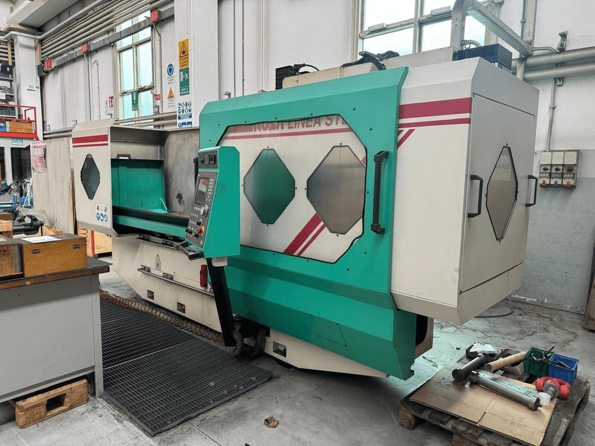 Zelenobílý přesný stroj, pohled zepředu, s ovládacím panelem, pracovním prostorem a nástroji na paletě. Značka: BAMB.