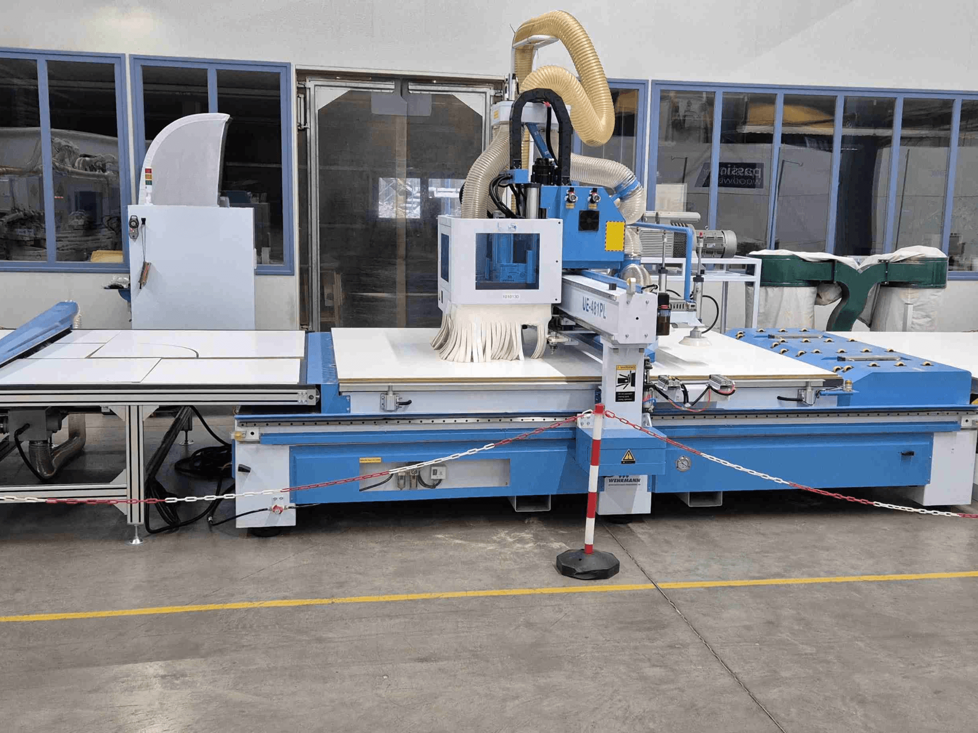 Modrá CNC frézka UE-621PL zepředu, s velkým řezacím stolem a připojeným systémem odsávání prachu.