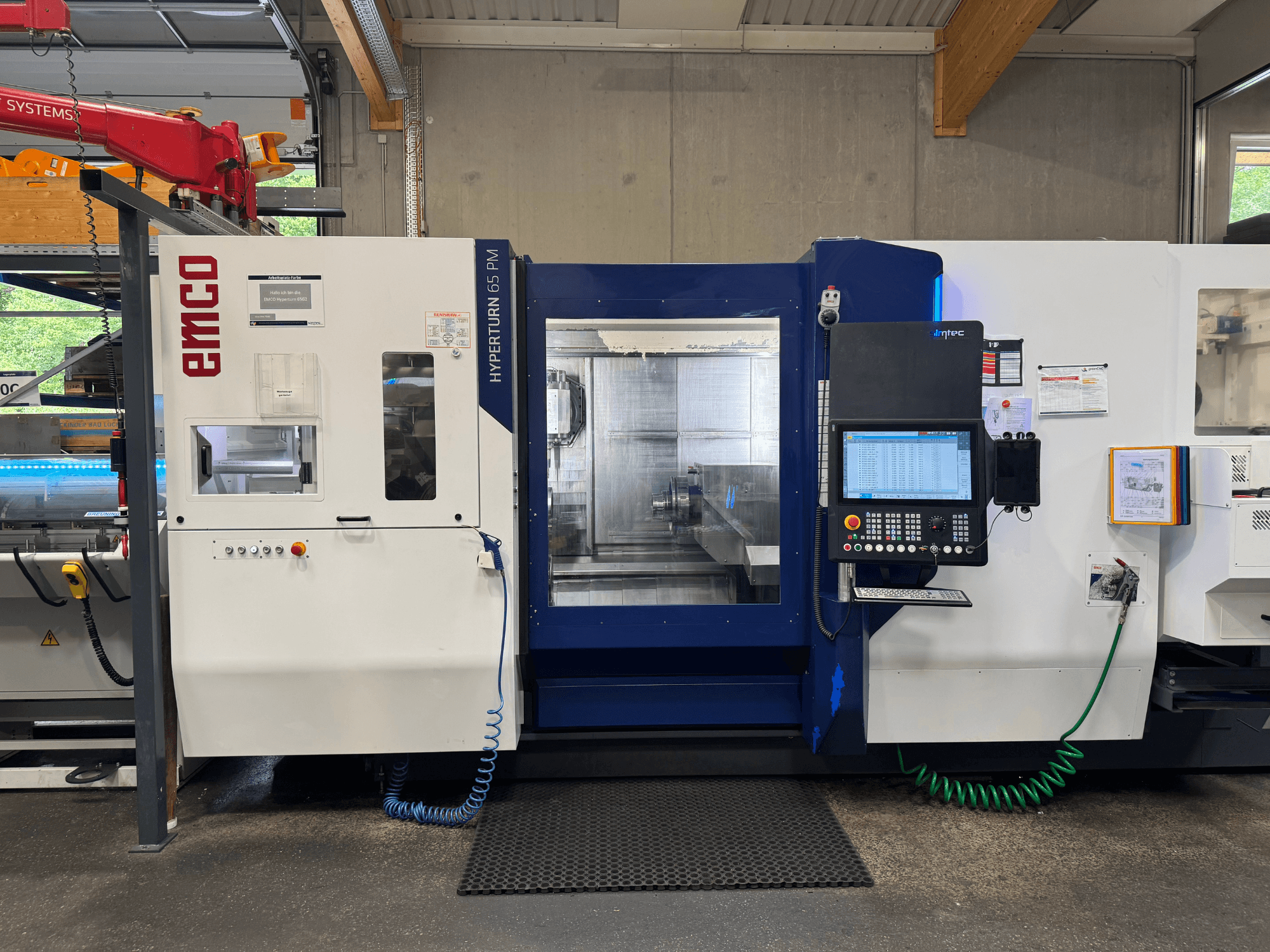 Stroj EMCO Hyperturn 65 PM, pohled zepředu, zobrazení ovládacího panelu, prostoru vřetena a provozních funkcí.