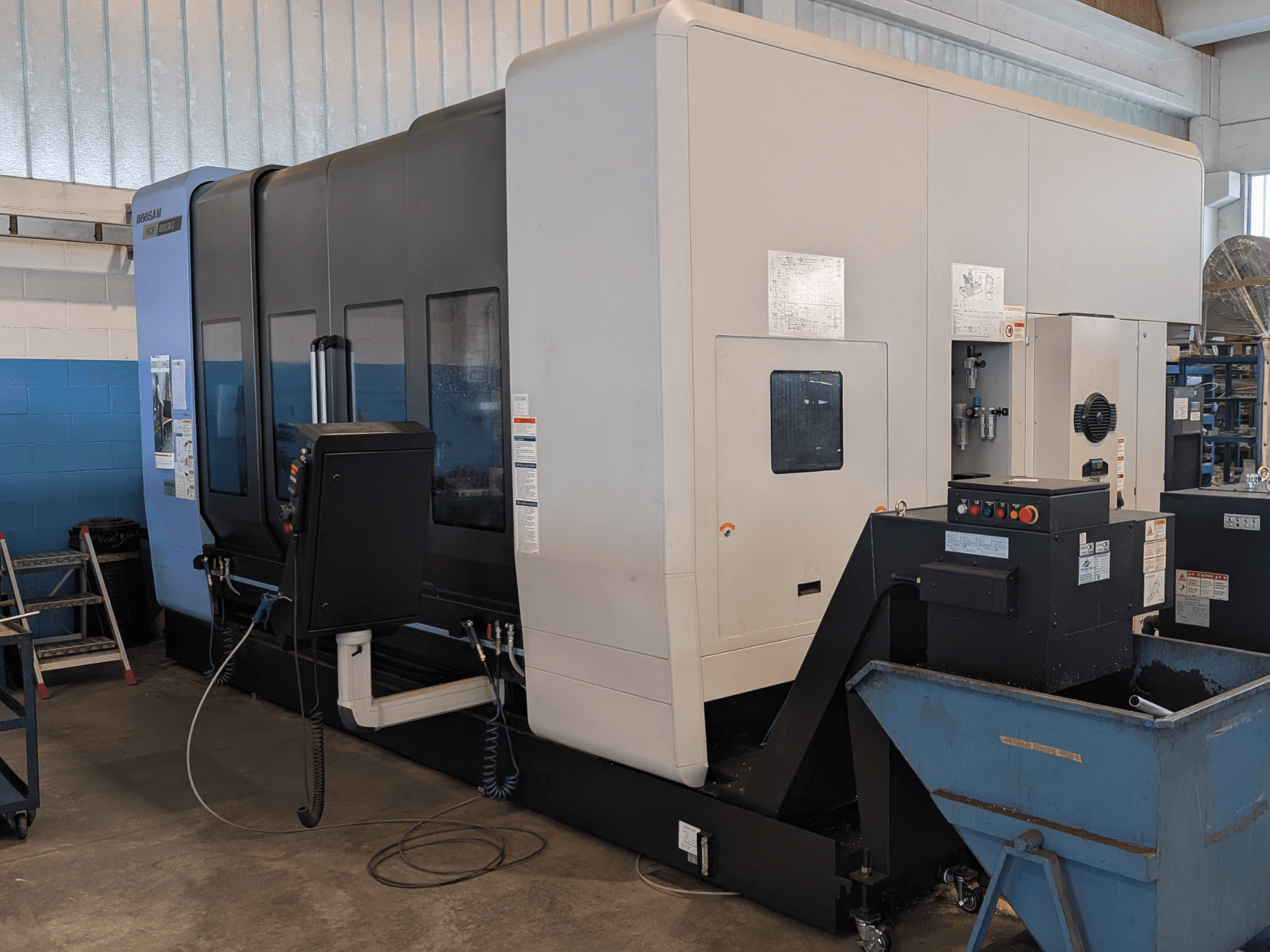 Vertikální obráběcí centrum DOOSAN VCF850LSR-II v bočním pohledu, na kterém je vidět ovládací panel, systém chlazení a robustní konstrukce.
