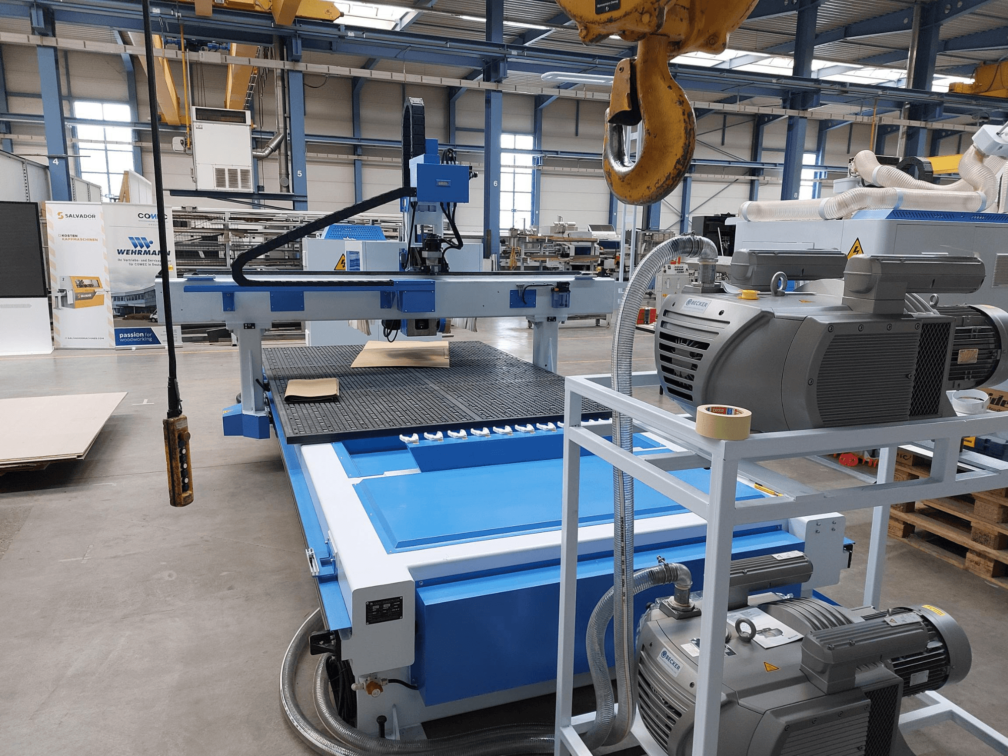 CNC dřevoobráběcí centrum QUICK CNC UA 481, pohled zepředu znázorňující ovládací panel, motory a pracovní plochu s kusem dřeva.