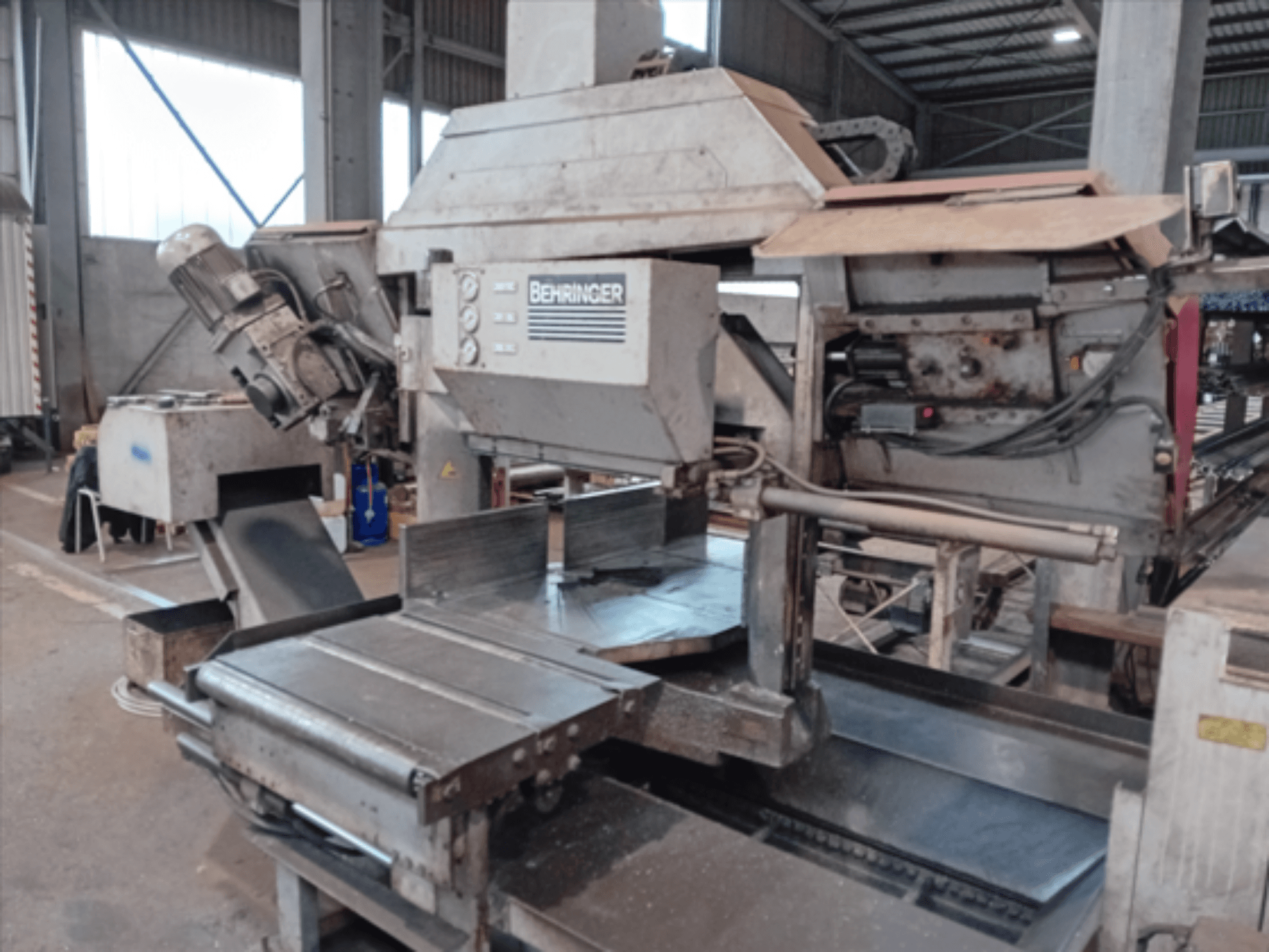 Pásová pila Behringer, pohled zepředu, s velkým kotoučem, motorem a nastavitelným stolem, ideální pro řezání kovů v dílně.