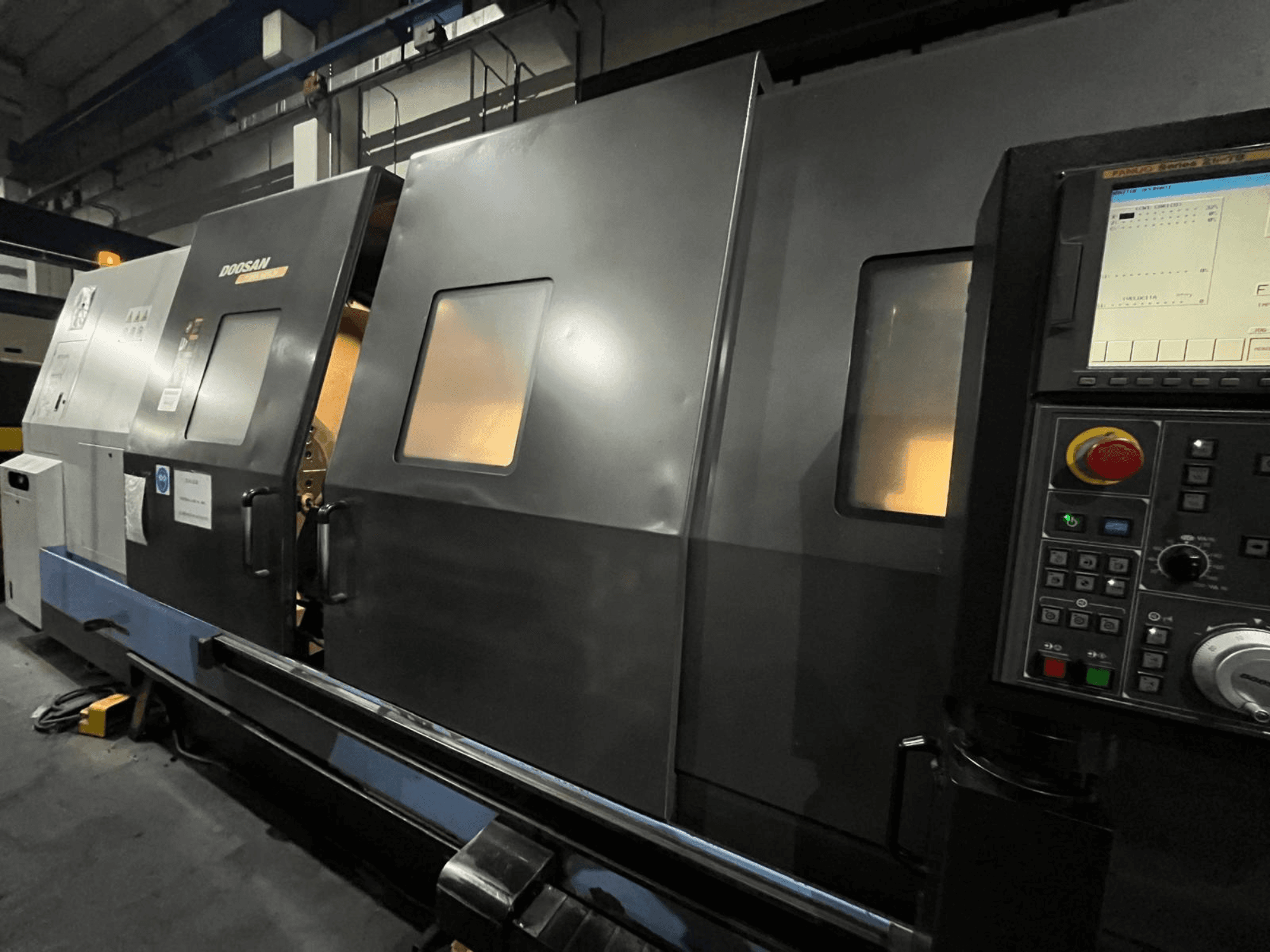 CNC soustruh Doosan v čelním pohledu, s ovládacím panelem a rozhraním obsluhy s viditelným digitálním displejem a tlačítky.