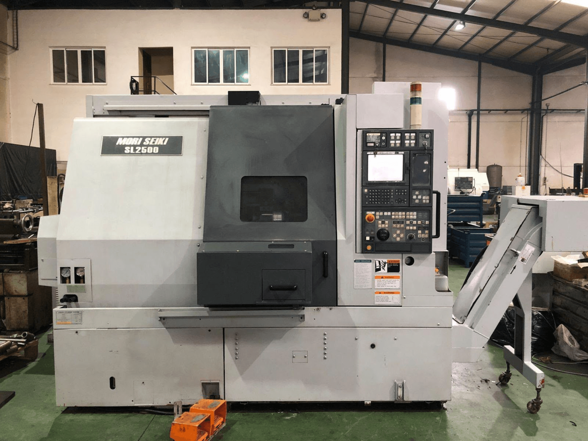 Otočné frézovací centrum DMG Mori Seiki SL 2500 Y, boční pohled s viditelným ovládacím panelem a dopravníkem třísek.