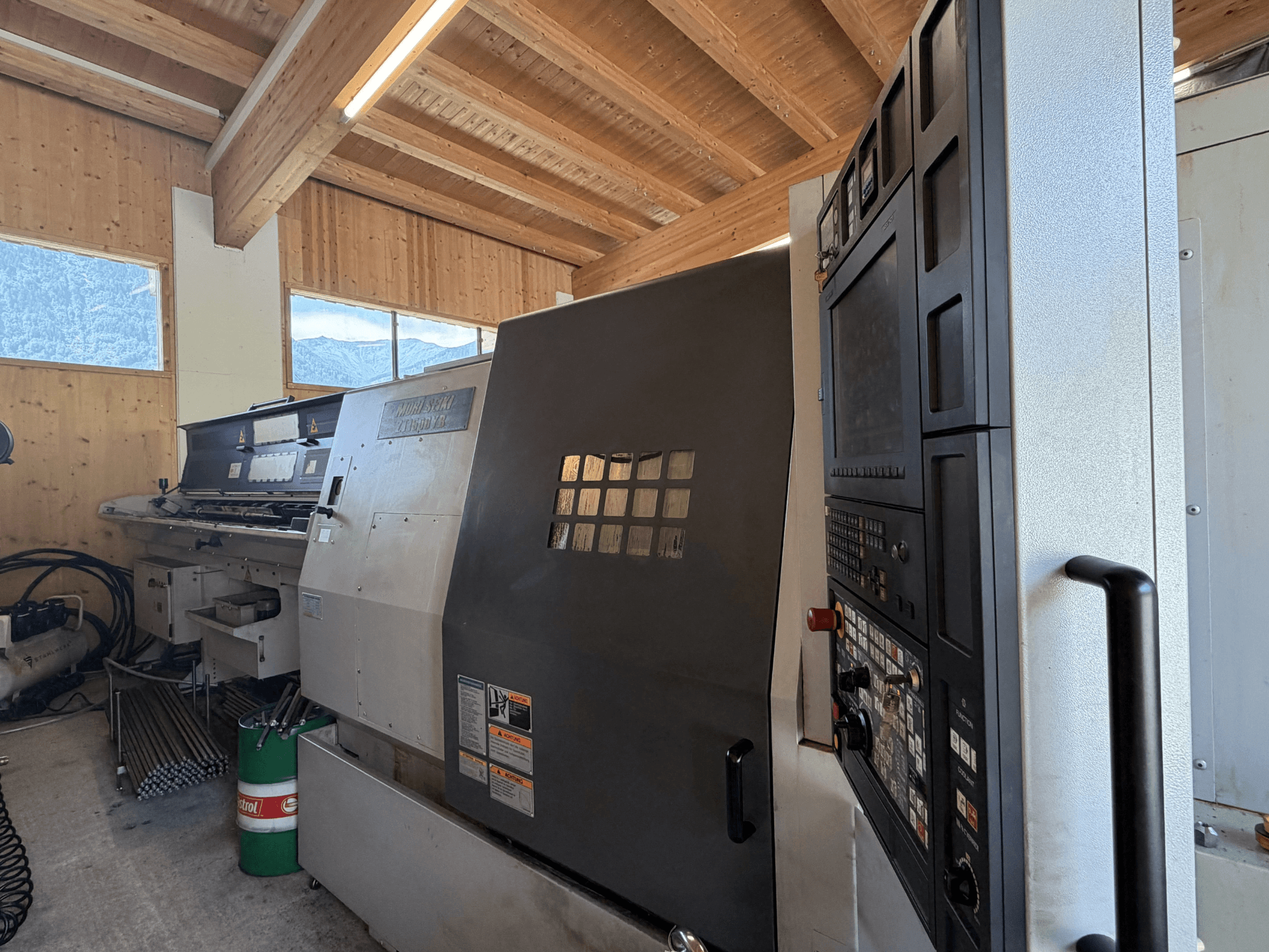 Soustružnicko-frézovací centrum MORI SEIKI ZT1500YB v dílně, boční pohled znázorňující ovládací panel a vlastnosti stroje.