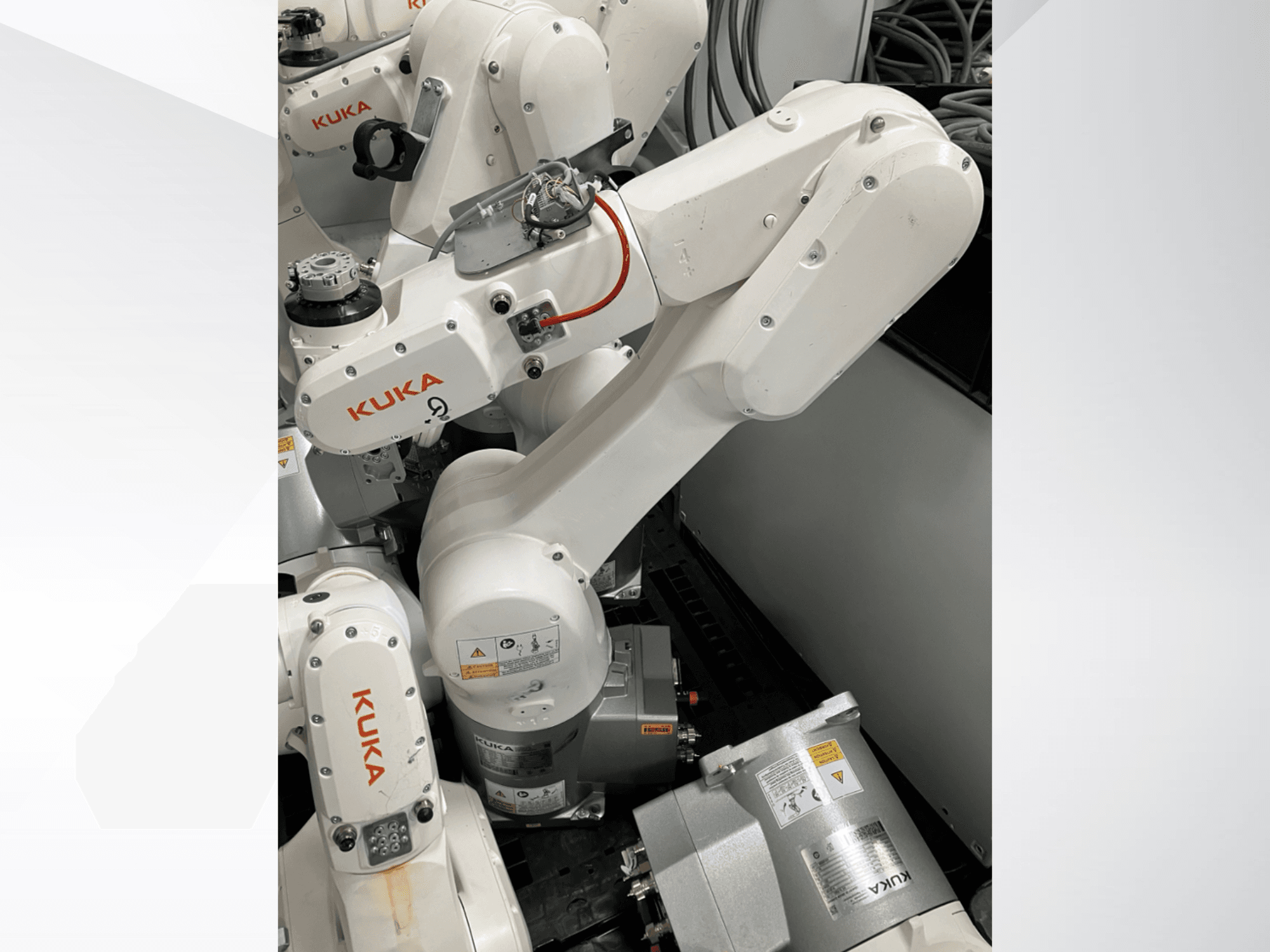 Robotické rameno KUKA KR 6 R900 CR, boční pohled; viditelné motory a konektory, označená bezpečnostní upozornění a mechanická ramena.